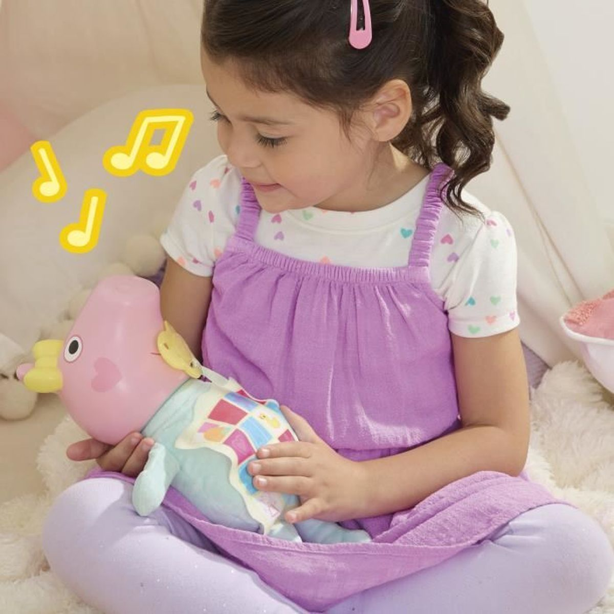 Ein Mädchen in lila Kleid hält ein Spielzeug. Musikalische Noten sind um sie herum. Sie sitzt auf einer flauschigen weißen Oberfläche.