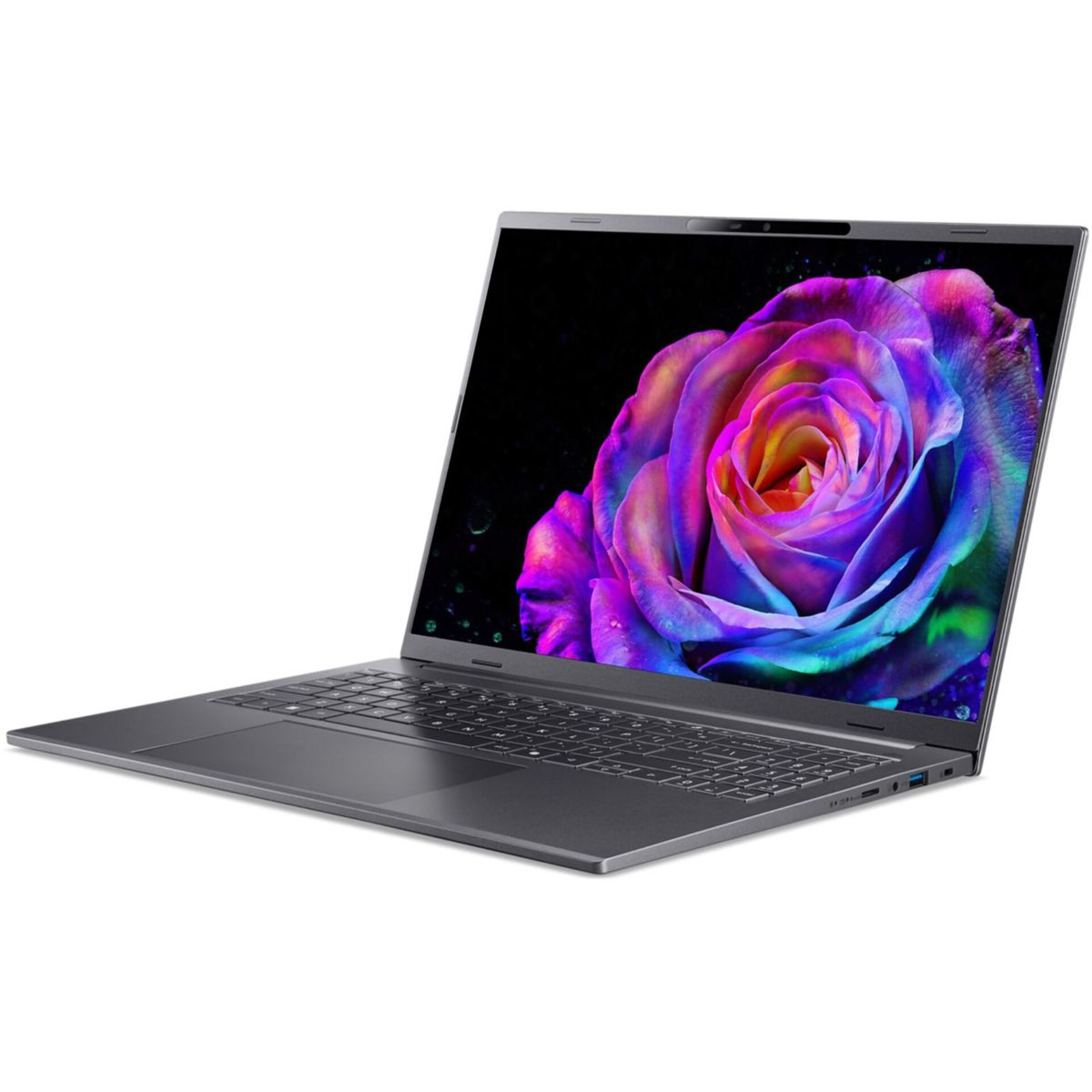 Szary laptop jest otwarty, wyświetlając kolorową różę na ekranie. Tło jest białe.