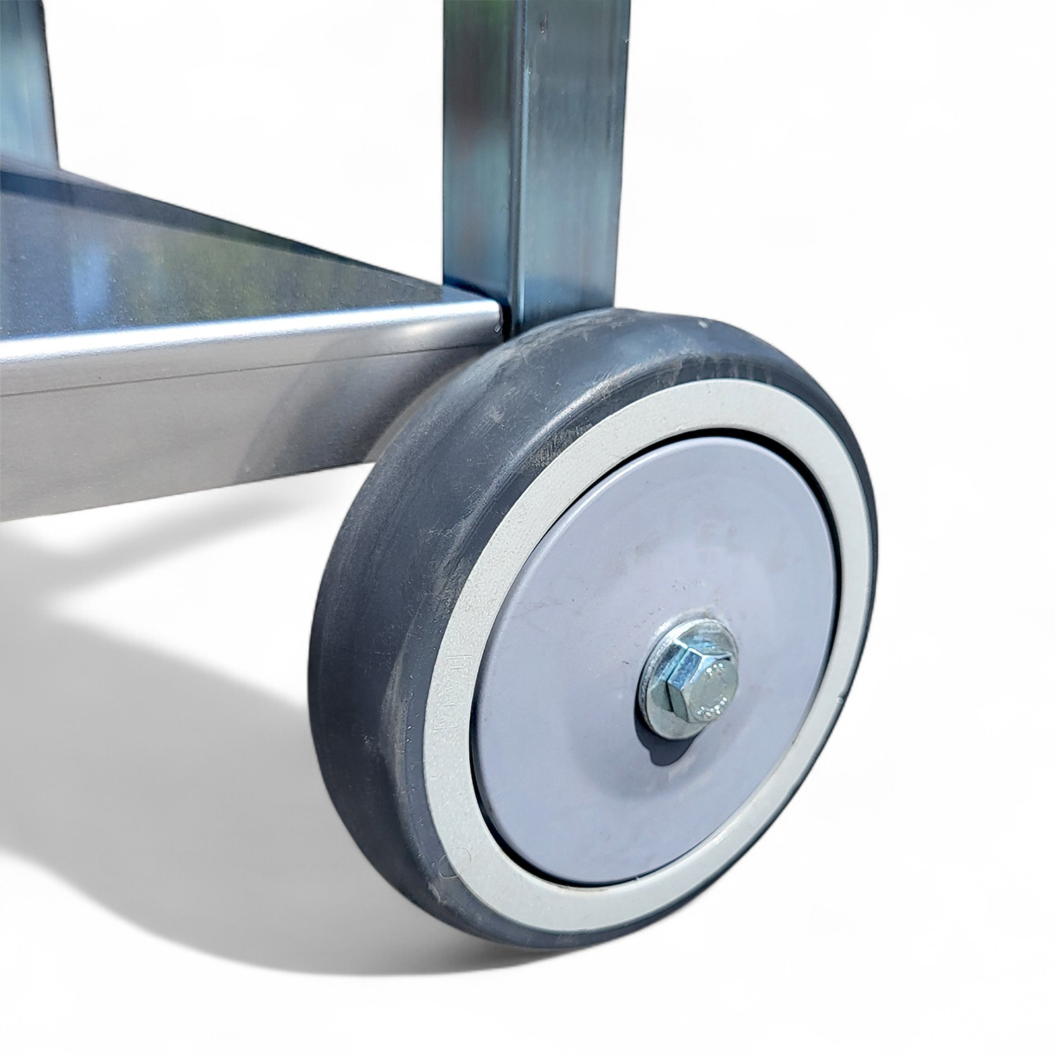 Nahaufnahme eines Metallwagenrads. Das Rad ist grau mit weißer Zierleiste. Eine große Schraube sichert das Rad.