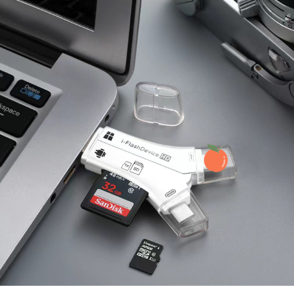 Ein weißes i-FlashDevice HD mit einer eingelegten SanDisk SD-Karte und einer weiteren SD-Karte. Das Gerät befindet sich neben einem Laptop.