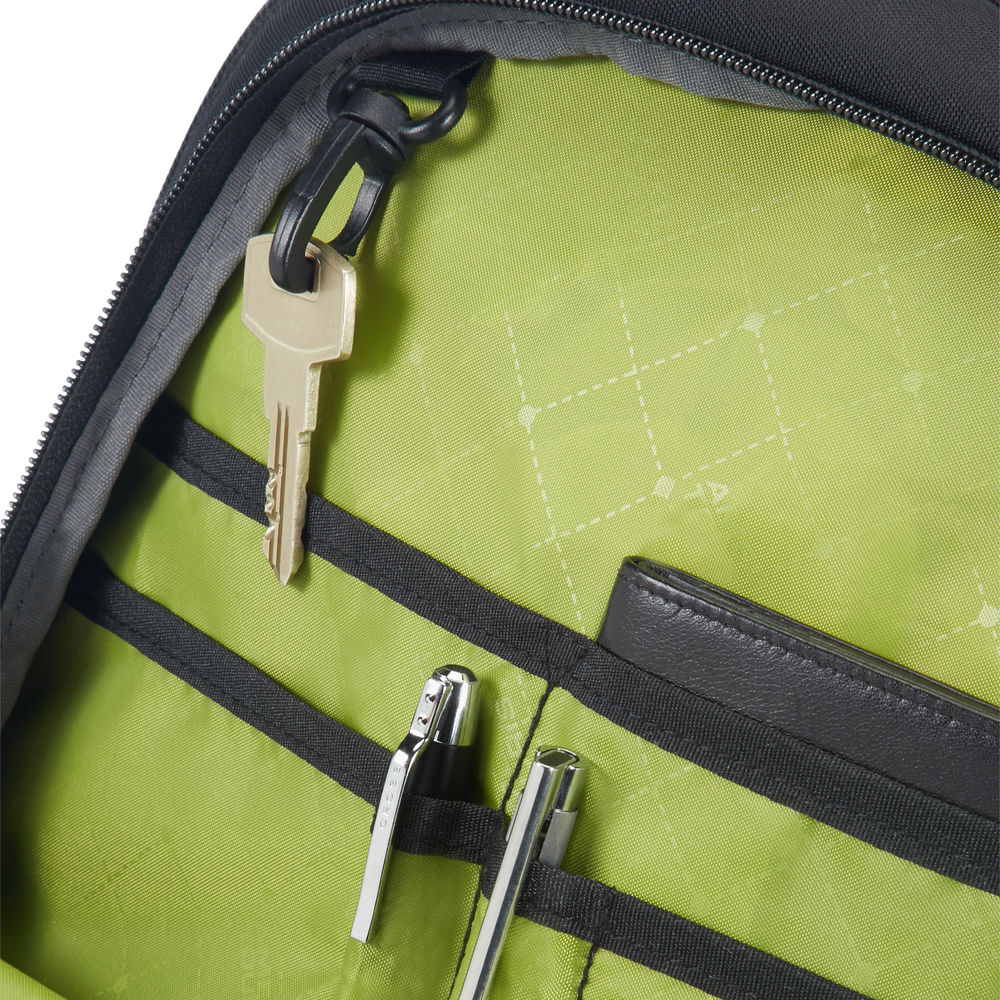 In einer Tasche: ein Schlüssel, Stifte und eine Geldbörse. Das Futter ist grün mit schwarzen Riemen. Die Tasche ist schwarz.