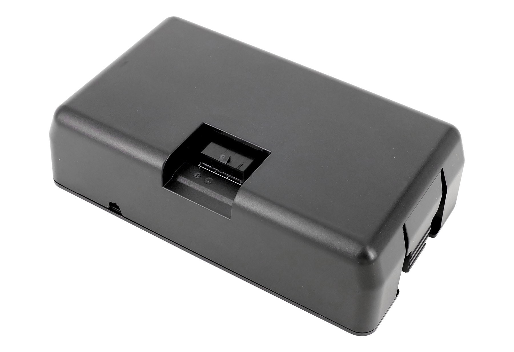 Ein schwarzes, rechteckiges Gerät mit einer Aussparung, möglicherweise ein Batterieladegerät, ist auf weißem Hintergrund isoliert.