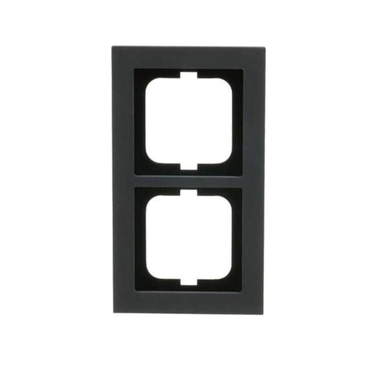 Una copertura per presa elettrica grigio scuro con due aperture quadrate. Lo sfondo è bianco.