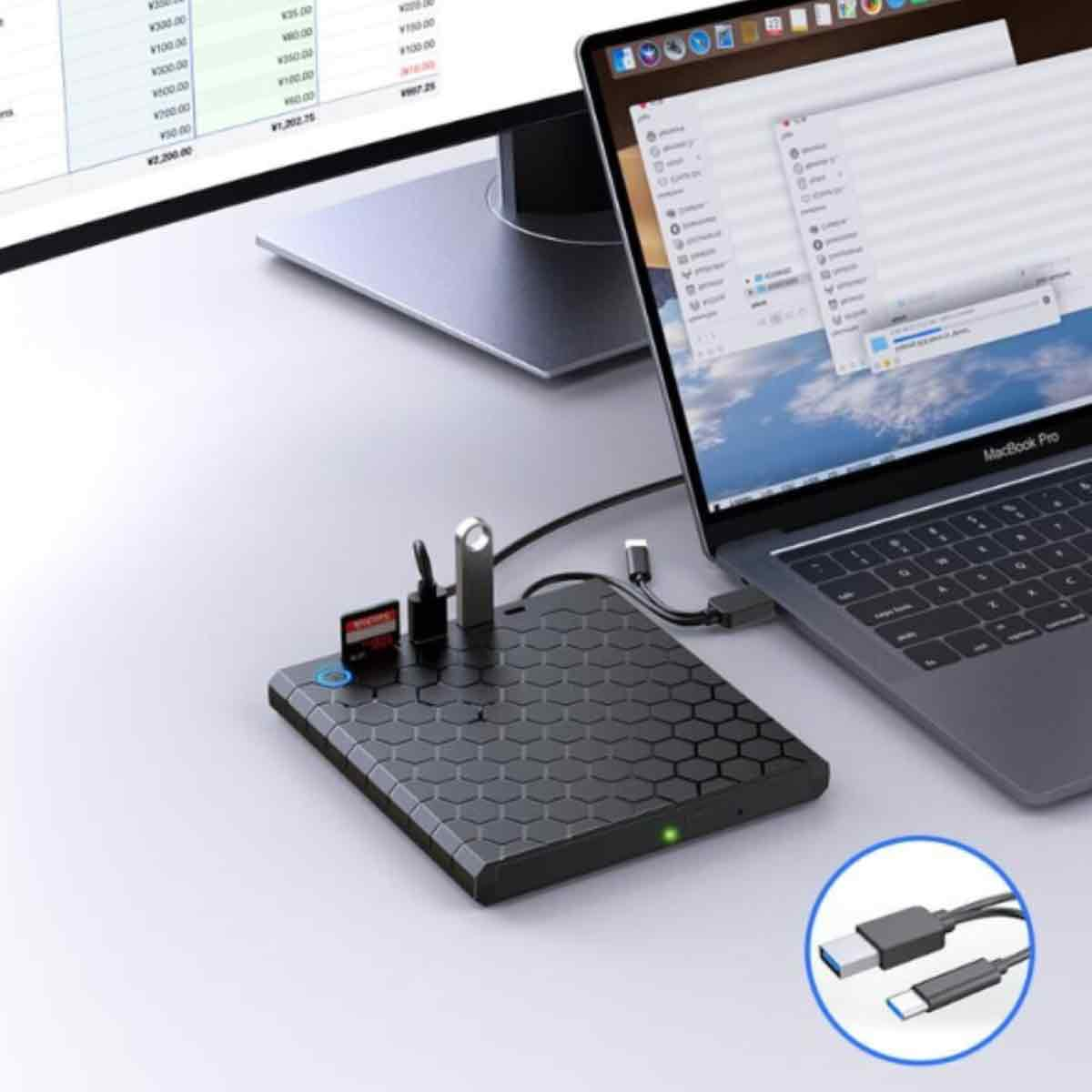 Ein Laptop ist mit einer Dockingstation verbunden. Im Hintergrund befindet sich ein Monitor. Kabel und eine Nahaufnahme von Steckern sind sichtbar.