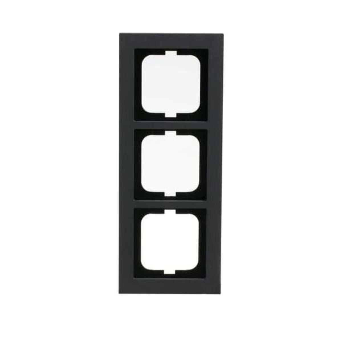 Una copertura per presa elettrica rettangolare nera con tre aperture bianche quadrate. Lo sfondo è bianco.