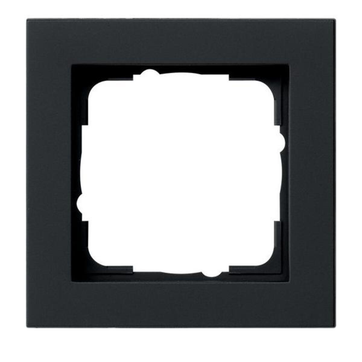 Una cornice quadrata nera per presa elettrica. Ha un'apertura quadrata con lati curvi. La cornice è nero opaco.