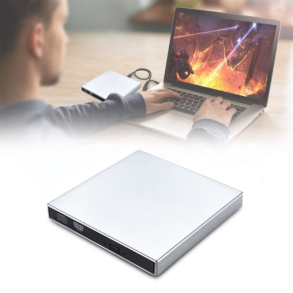 Eine Person benutzt einen Laptop. Ein silberner DVD-Player befindet sich im Vordergrund. Ein weiterer DVD-Player befindet sich neben dem Laptop.