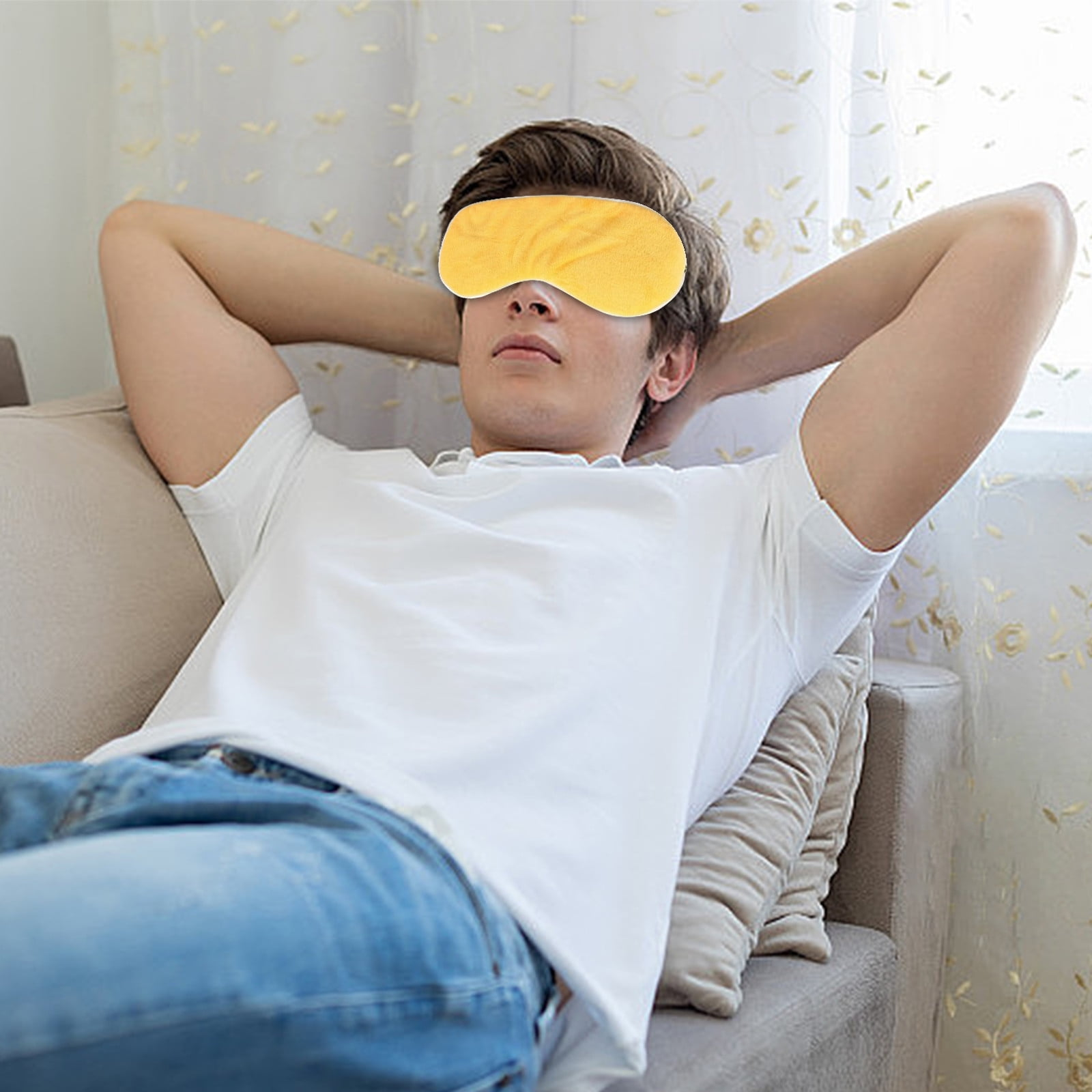 Ein Mann mit gelber Augenmaske entspannt sich auf einem Sofa. Er hat die Arme hinter dem Kopf, ein weißes Hemd und Jeans.