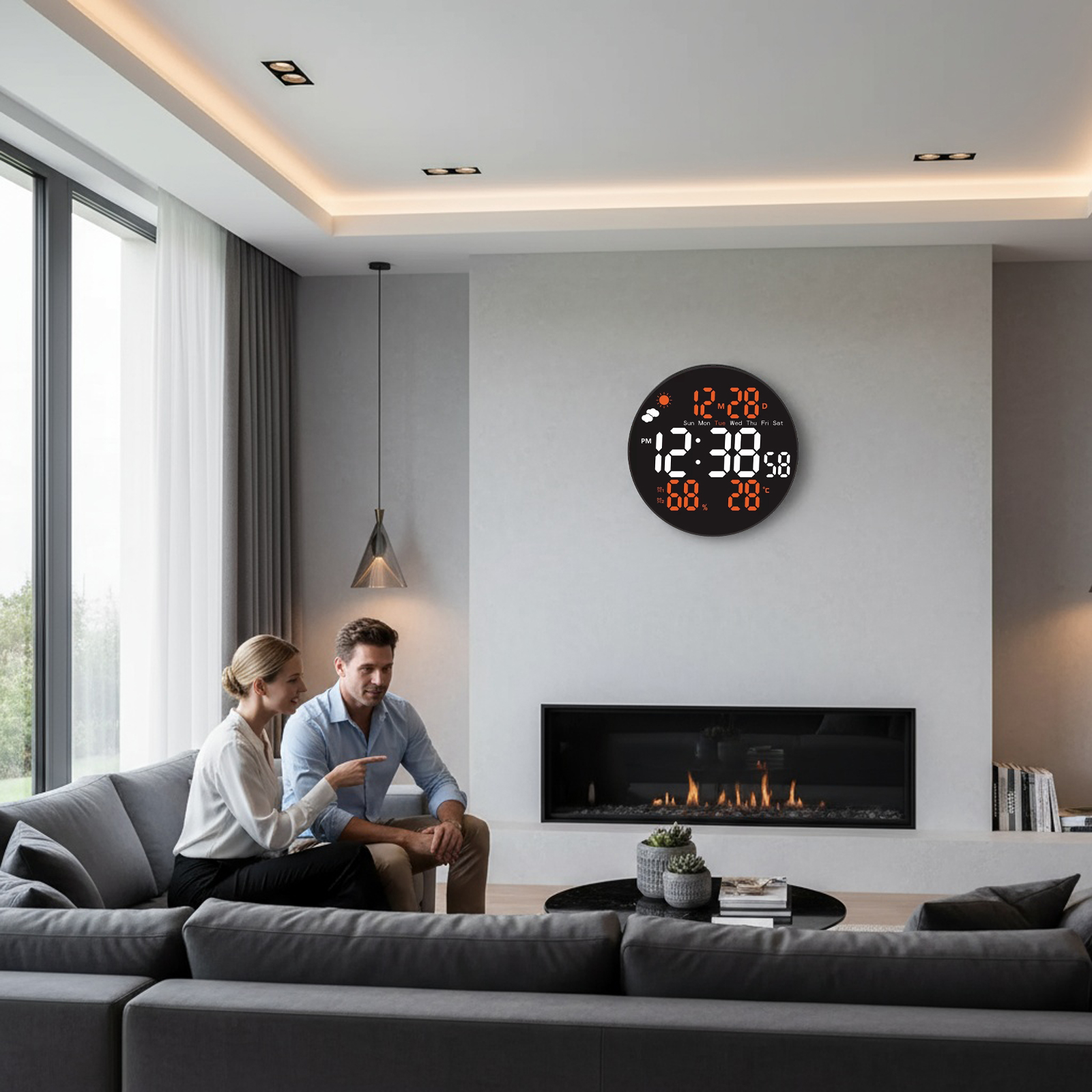 Ein Paar sitzt auf einem grauen Sofa in einem modernen Wohnzimmer. Eine Uhr und ein Kamin sind an der Wand.