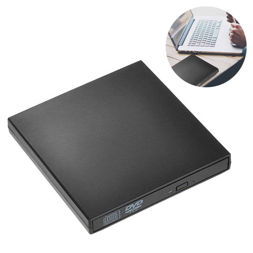 Ein schwarzes DVD-Laufwerk liegt auf einer weißen Oberfläche. Ein Laptop und eine Hand mit Telefon sind rechts oben.