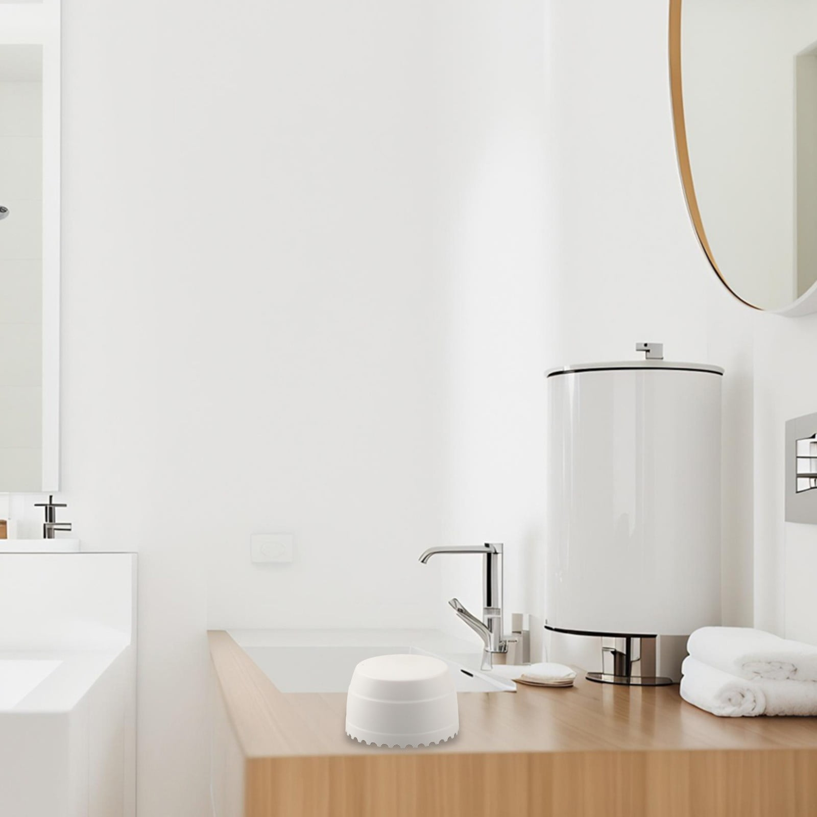 Ein modernes Badezimmer mit weißem Thema. Waschbecken, Wasserhahn und ein großer weißer Zylinder. Handtücher und Seife sind ebenfalls sichtbar.