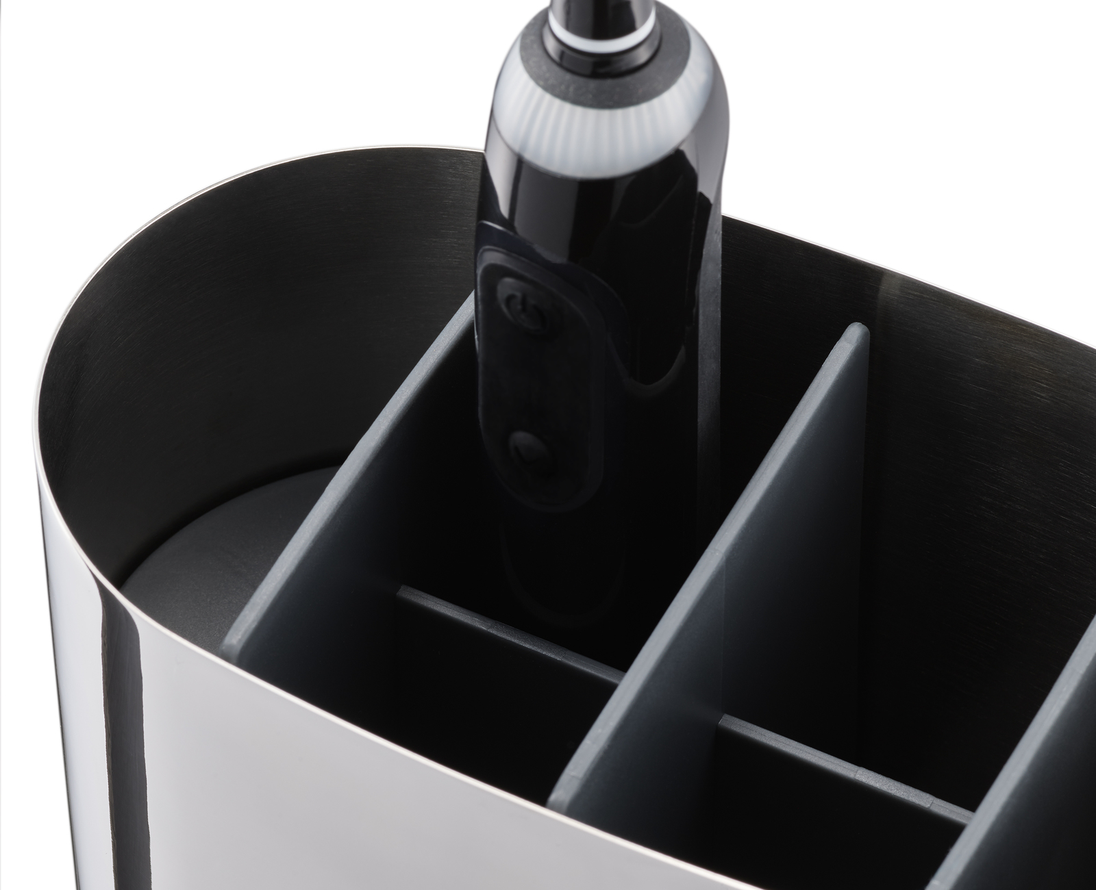 Primo piano di un contenitore in acciaio inossidabile con divisori grigi. All'interno c'è uno spazzolino elettrico bianco e nero.