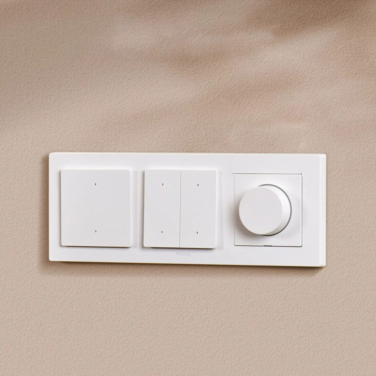 Weiße Lichtschalter und ein Dimmer an einer beigen Wand. Die Schalter sind rechteckig, der Dimmer ein runder Knopf.