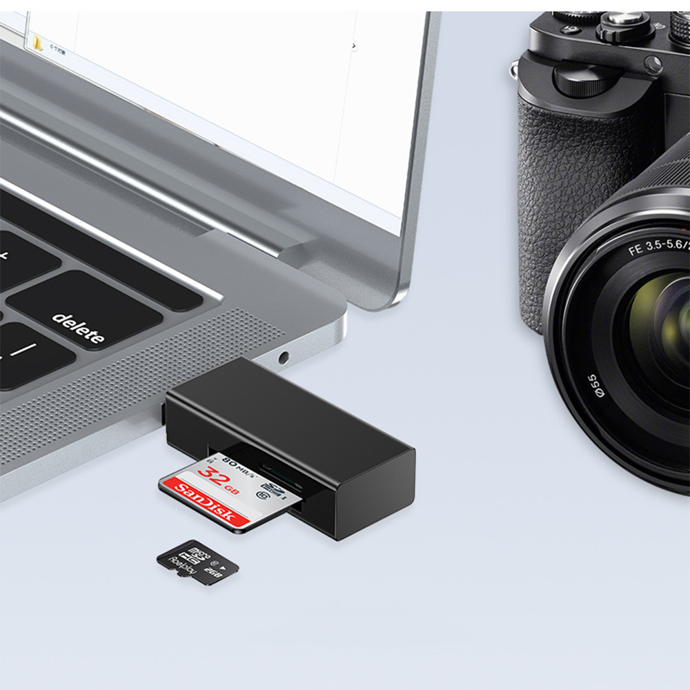 Ein Laptop und eine Kamera befinden sich neben einem schwarzen SD-Kartenleser. Eine Sandisk SD-Karte ist eingesetzt. Eine kleinere microSD-Karte ist unten.