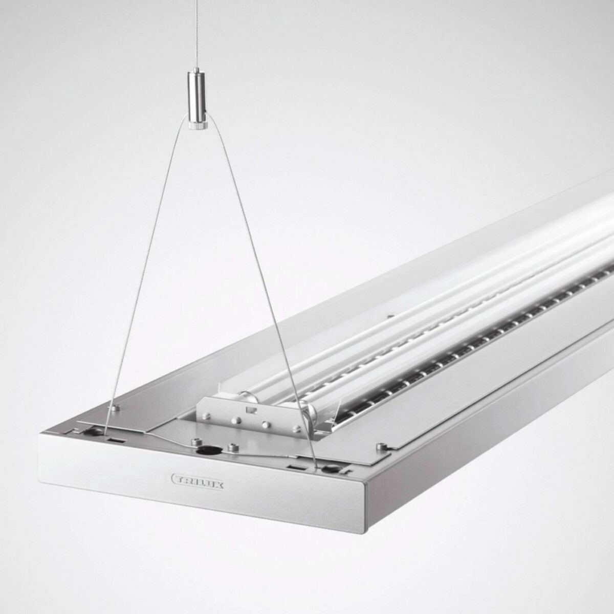 Una moderna lampada rettangolare argentata, sospesa con fili al soffitto. Ha una copertura trasparente e tubi fluorescenti all'interno.