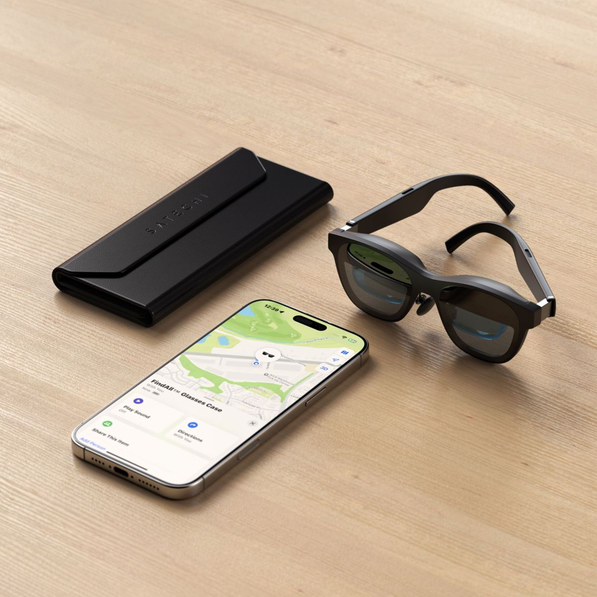 Schwarze Brille, Etui und ein Telefon mit einer Karte auf einer Holzoberfläche. Das Telefon zeigt 'FindAll Glasses Case'.