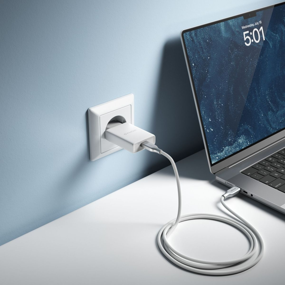 Ein Laptop wird mit einem weißen Ladegerät aufgeladen, das an eine Steckdose angeschlossen ist. Das Kabel ist mit dem Laptop verbunden.
