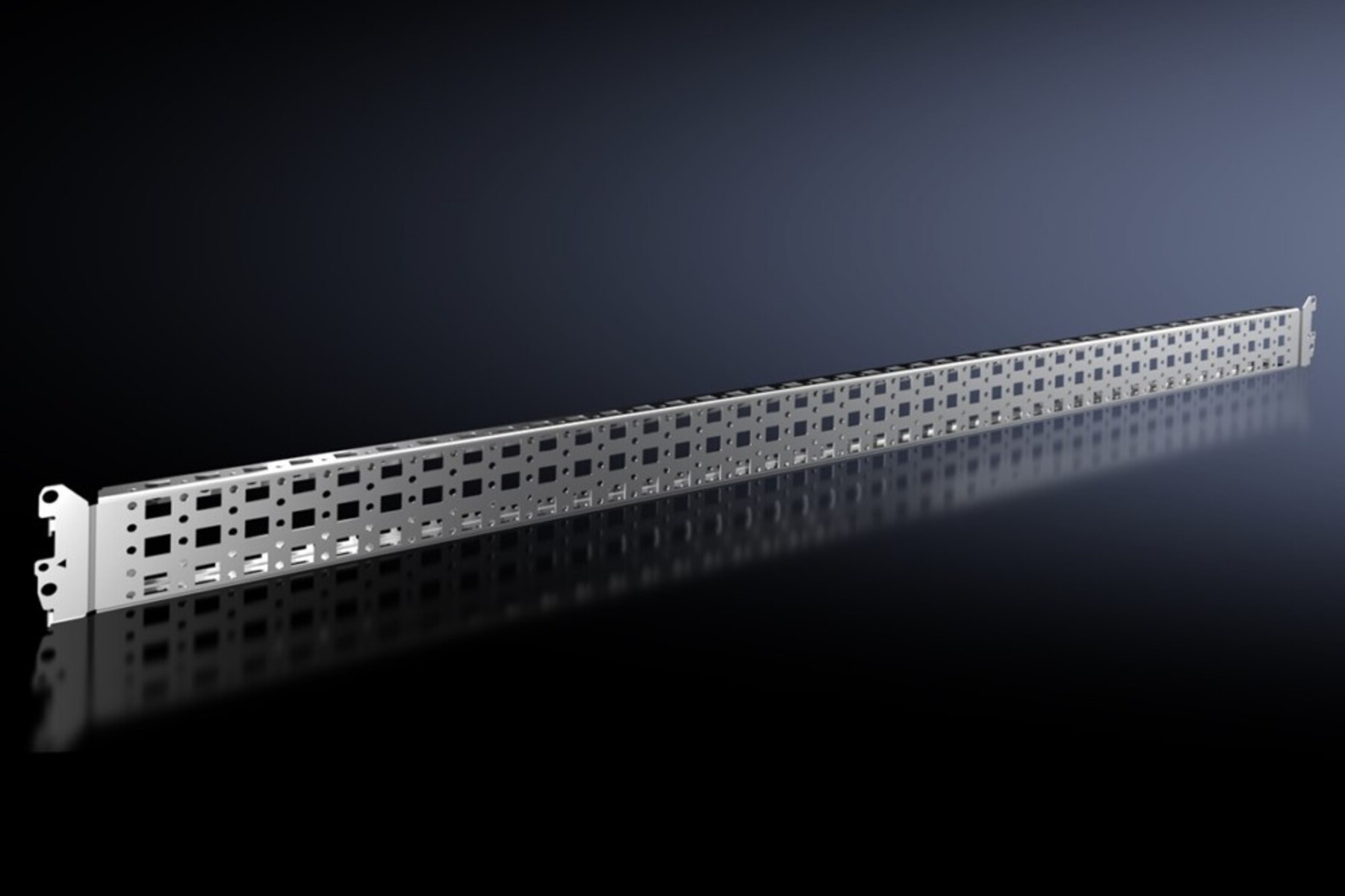 Un lungo componente metallico rettangolare argentato con molti fori quadrati, appoggiato su una superficie scura e riflettente.