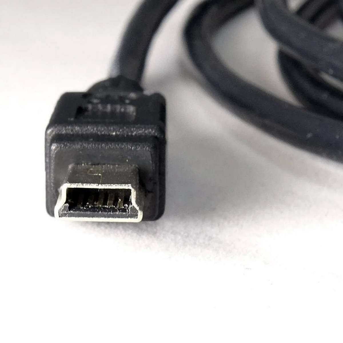 Nahaufnahme eines schwarzen USB-Kabelanschlusses vor weißem Hintergrund. Der Stecker ist scharfgestellt mit detaillierter Ansicht.