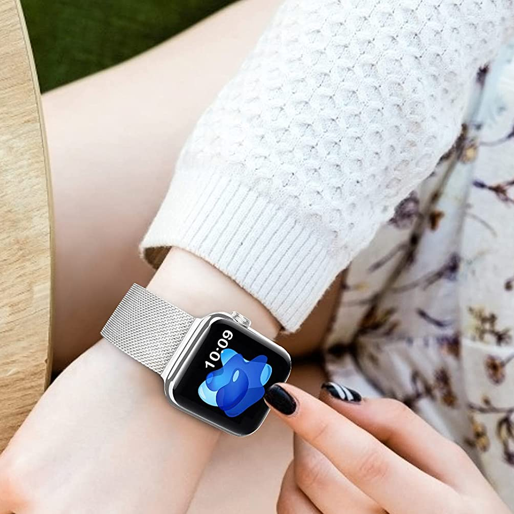 Das Handgelenk einer Frau mit einer silbernen Smartwatch. Die Uhr zeigt die Uhrzeit und ein blaues Design an. Die Nägel der Frau sind schwarz lackiert.