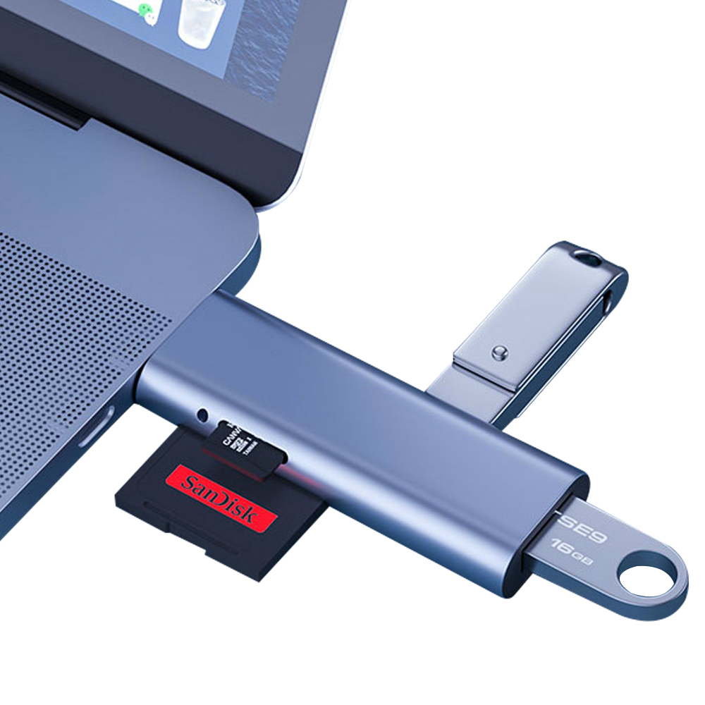 Ein Laptop mit einem grauen USB-C-Hub. Eine schwarze SanDisk SD-Karte und ein silberner USB-Stick sind eingesteckt.