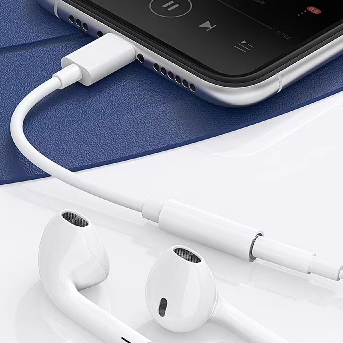 Weiße Kopfhörer sind mit einem Telefon verbunden. Das Telefon ist schwarz und silber, der Hintergrund ist blau. Die Kopfhörer und das Kabel sind weiß.