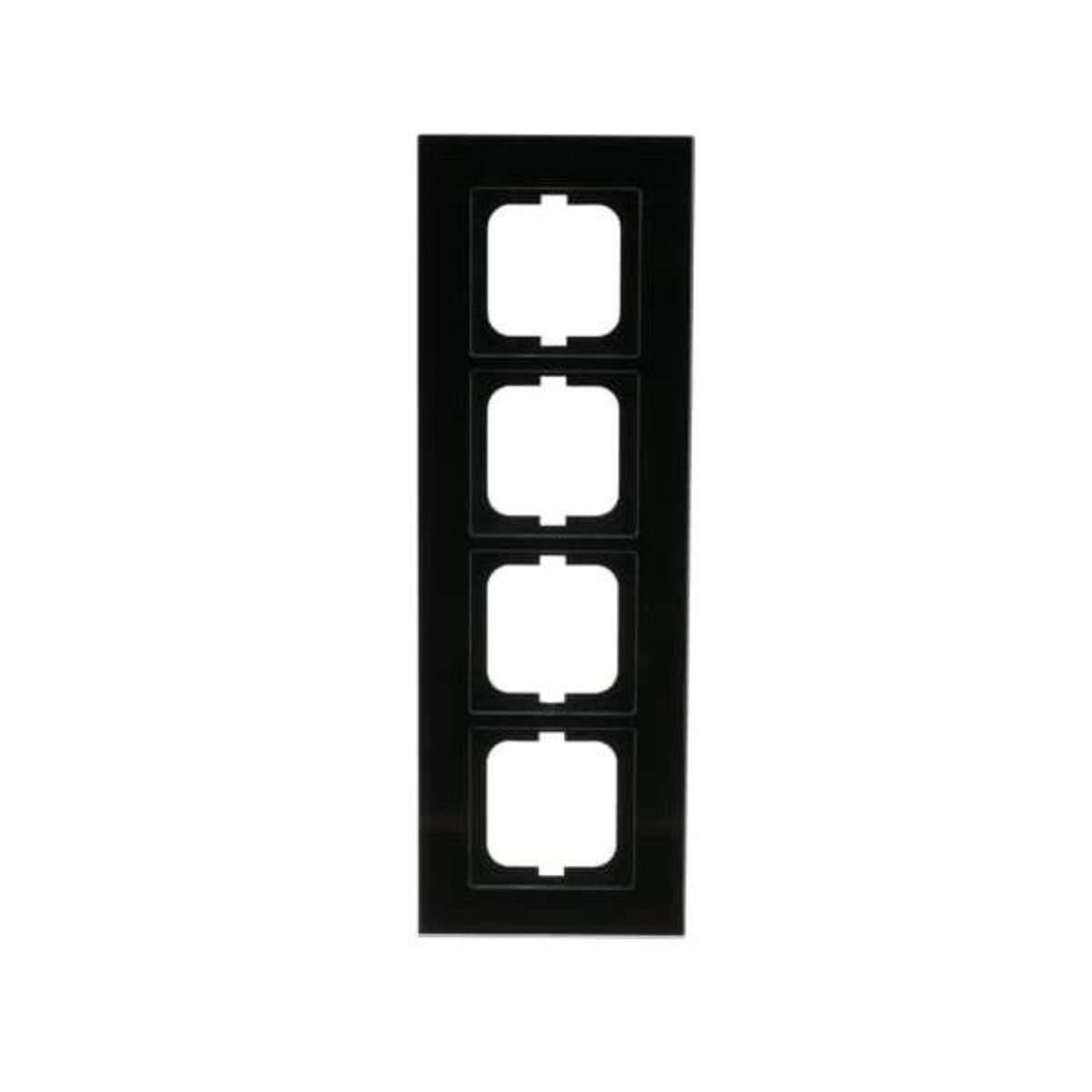 Una placca frontale per prese elettriche nera con quattro aperture quadrate. Lo sfondo è bianco.