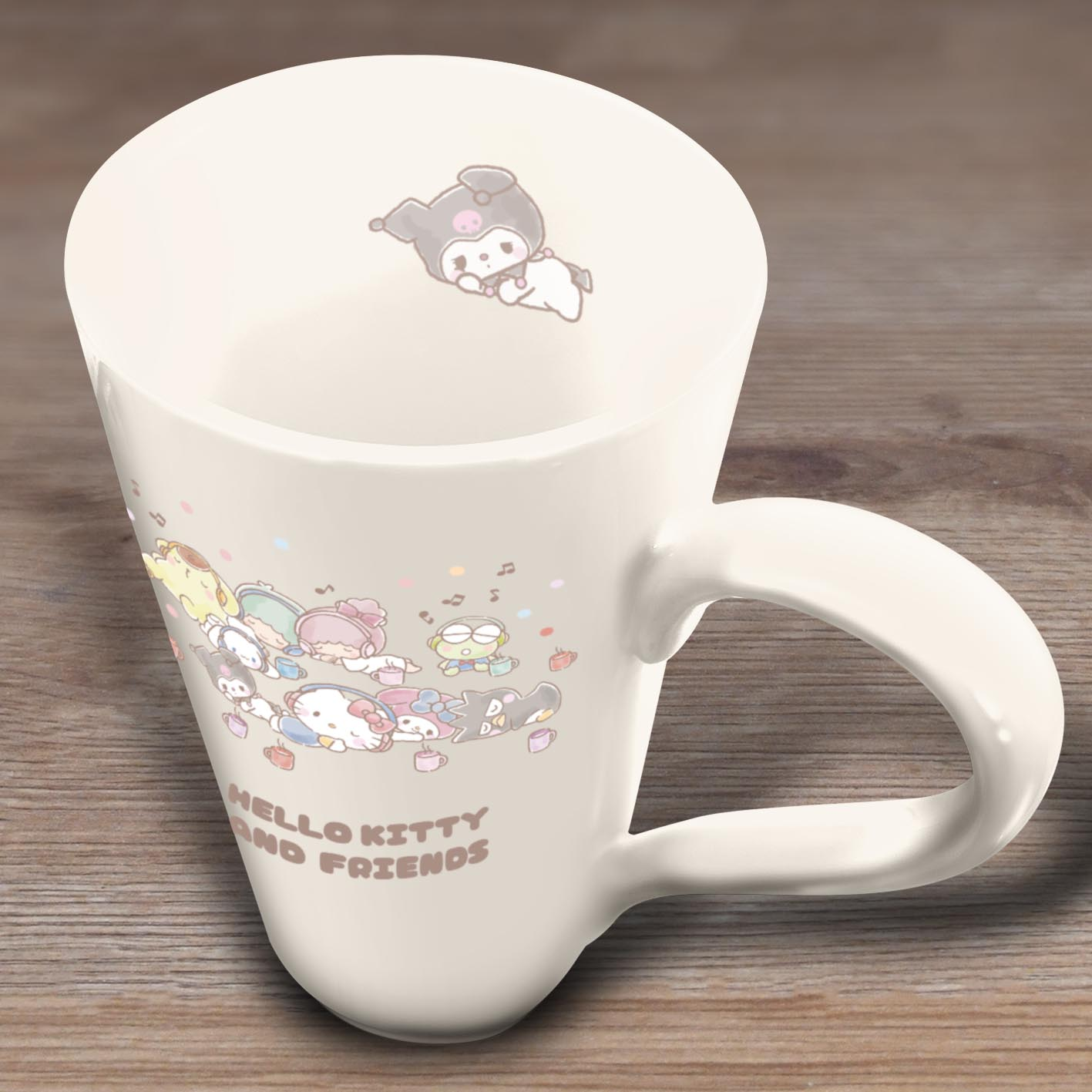 Eine weiße Tasse mit Hello Kitty und Friends-Charakteren. Die Tasse steht auf einer Holzoberfläche.