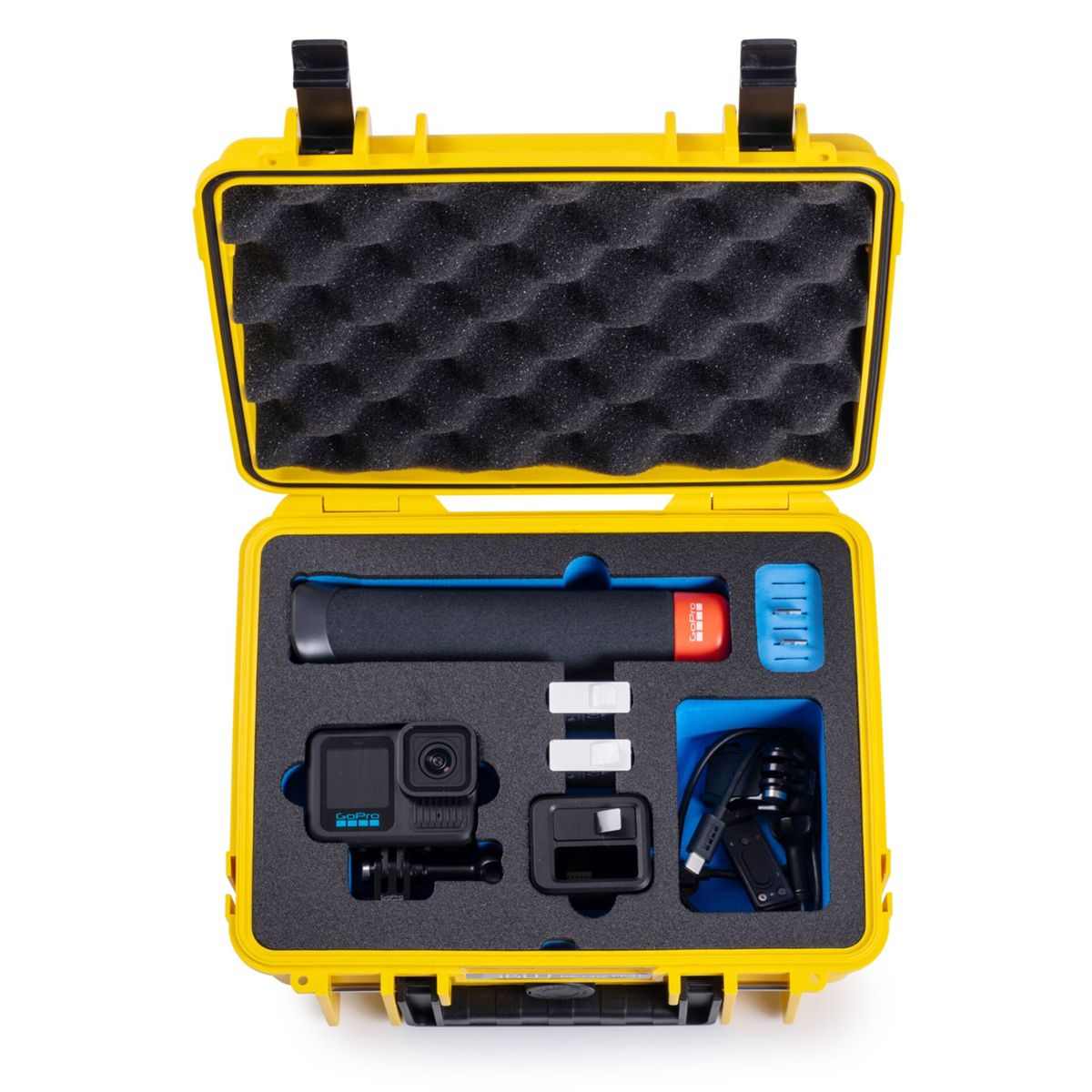 Geöffnete gelbe Box mit GoPro-Kamera und Zubehör. Enthält einen schwarzen Griff, blaue und weiße Komponenten und Schutzschaum.