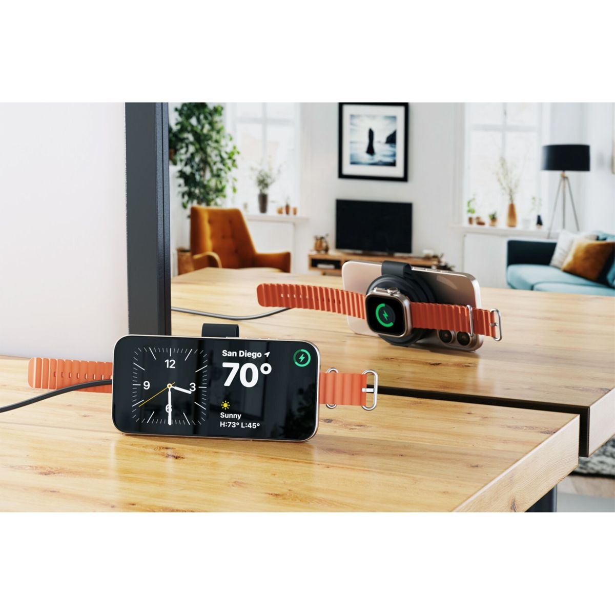 Zwei Smartwatches laden auf einem Holztisch. Eine zeigt die Zeit, Wetter in San Diego. Die andere lädt.