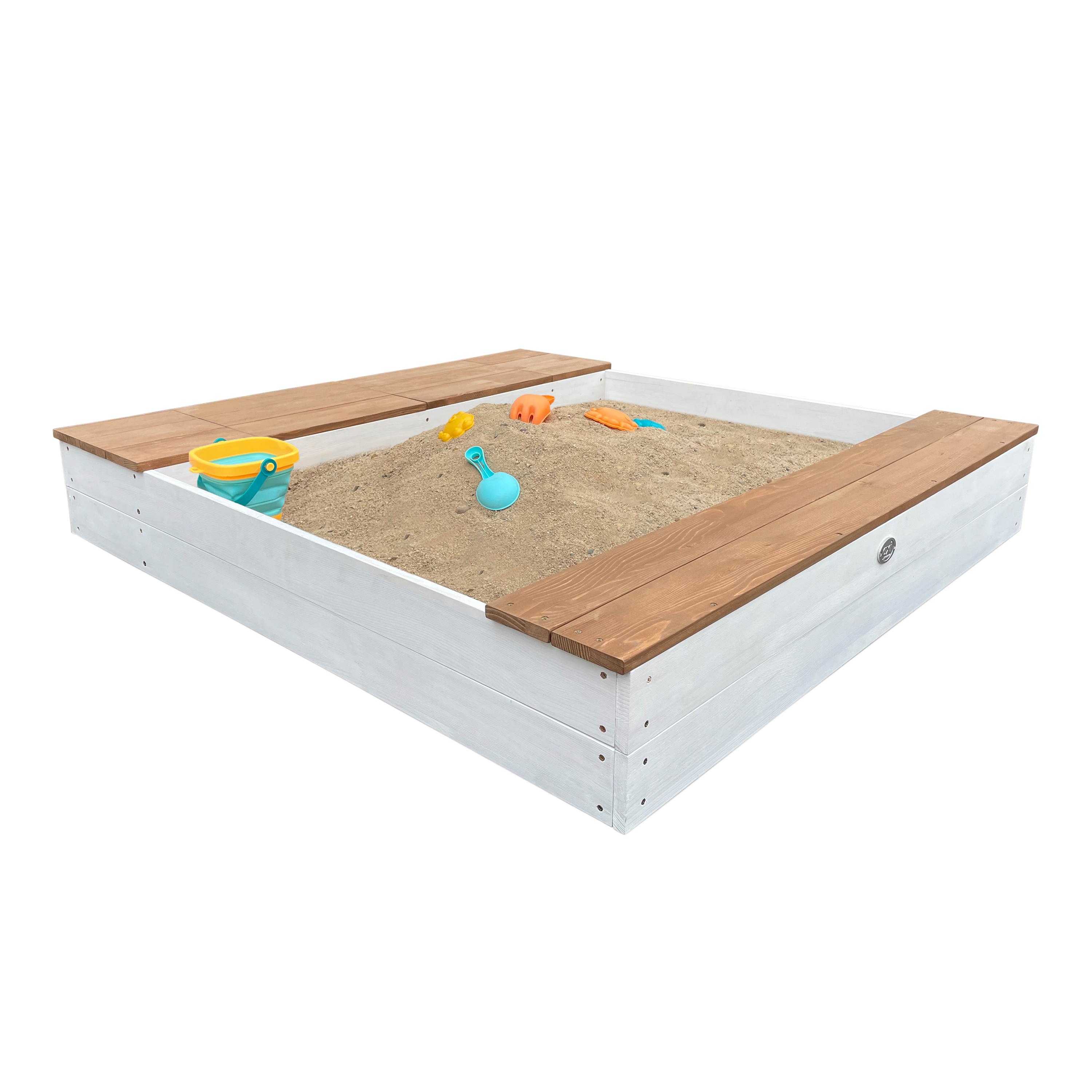 Ein weißer Sandkasten mit braunen Bänken, gefüllt mit Sand und Spielzeug: Eimer, Schaufel und Formen.