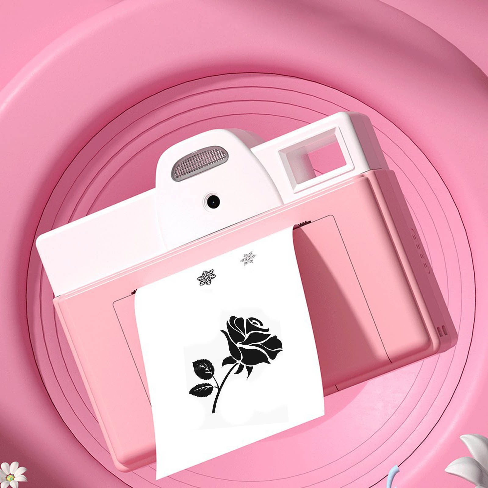 Rosa kameraförmiges Objekt mit weißer Oberseite, das ein Papier mit einer schwarzen Rosenzeichnung bedruckt, auf rosa Oberfläche.