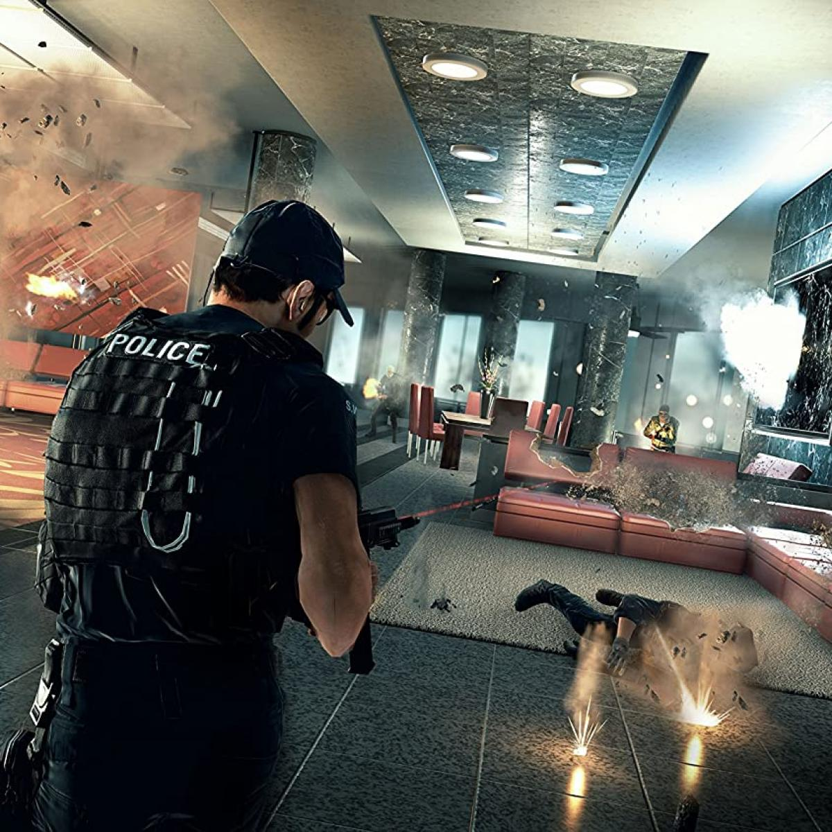 Funkcjonariusz policji w taktycznym wyposażeniu mierzy z broni w pomieszczeniu. Otaczają go eksplozje i odłamki. Osoba leży na podłodze.
