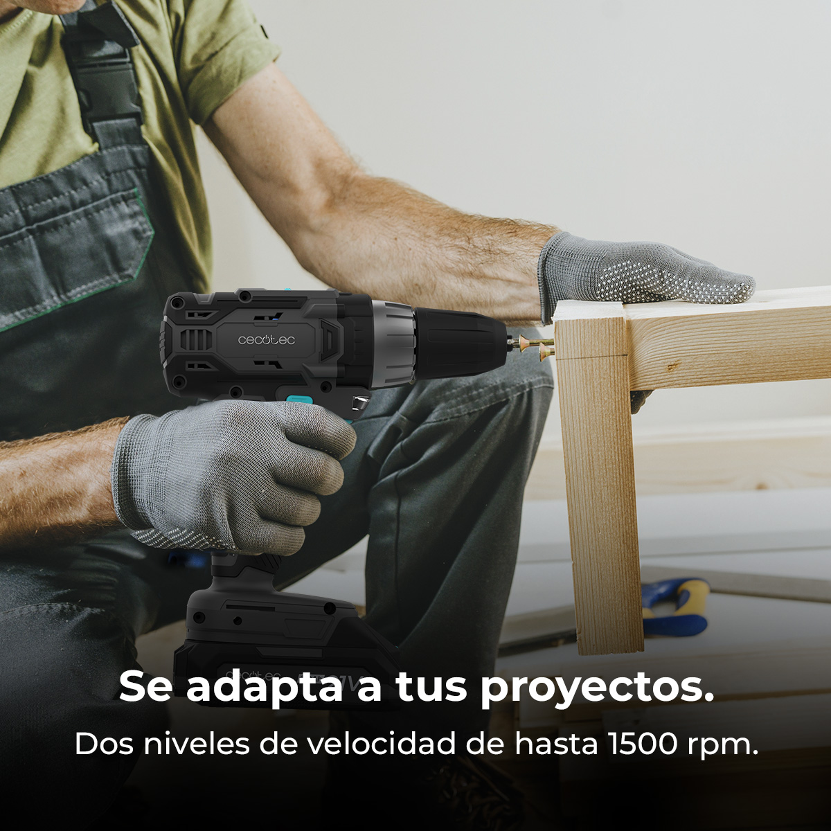 Una persona usa un trapano Cecotec nero e grigio per avvitare nel legno. La persona indossa guanti e tuta, in un'officina.