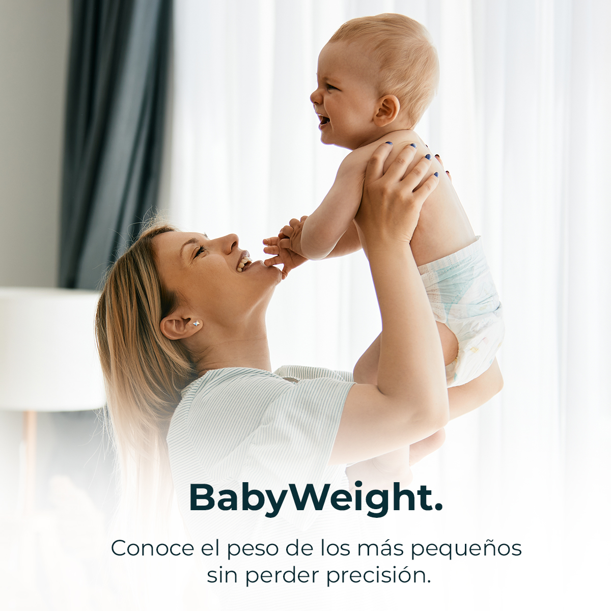 Eine Frau hält ein Baby hoch. Das Baby lacht. Die Frau lächelt. Sie befinden sich in einem hellen Raum.