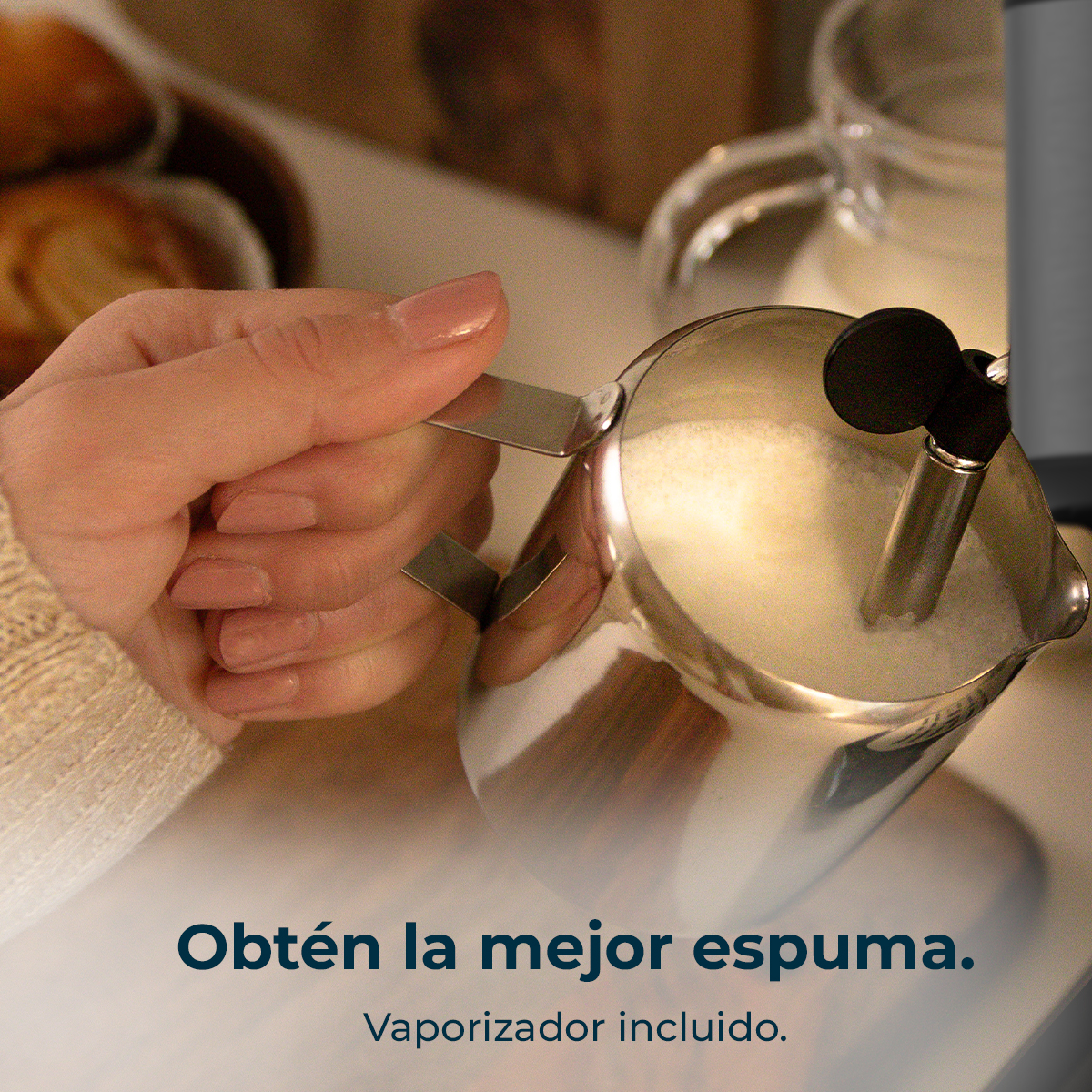 Una mano tiene una lattiera in acciaio inossidabile con latte schiumoso. Il testo dice: Ottieni la migliore schiuma. Vaporizzatore incluso.