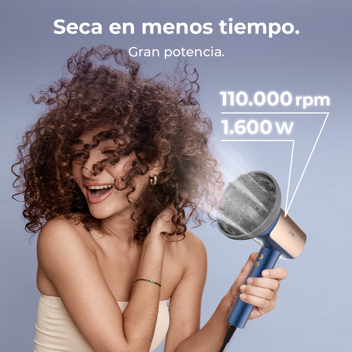 Donna con capelli ricci sorridente, usa un asciugacapelli blu e oro. Il testo recita 'Seca en menos tiempo. Gran potencia.' e '110.000 rpm, 1.600 w'.