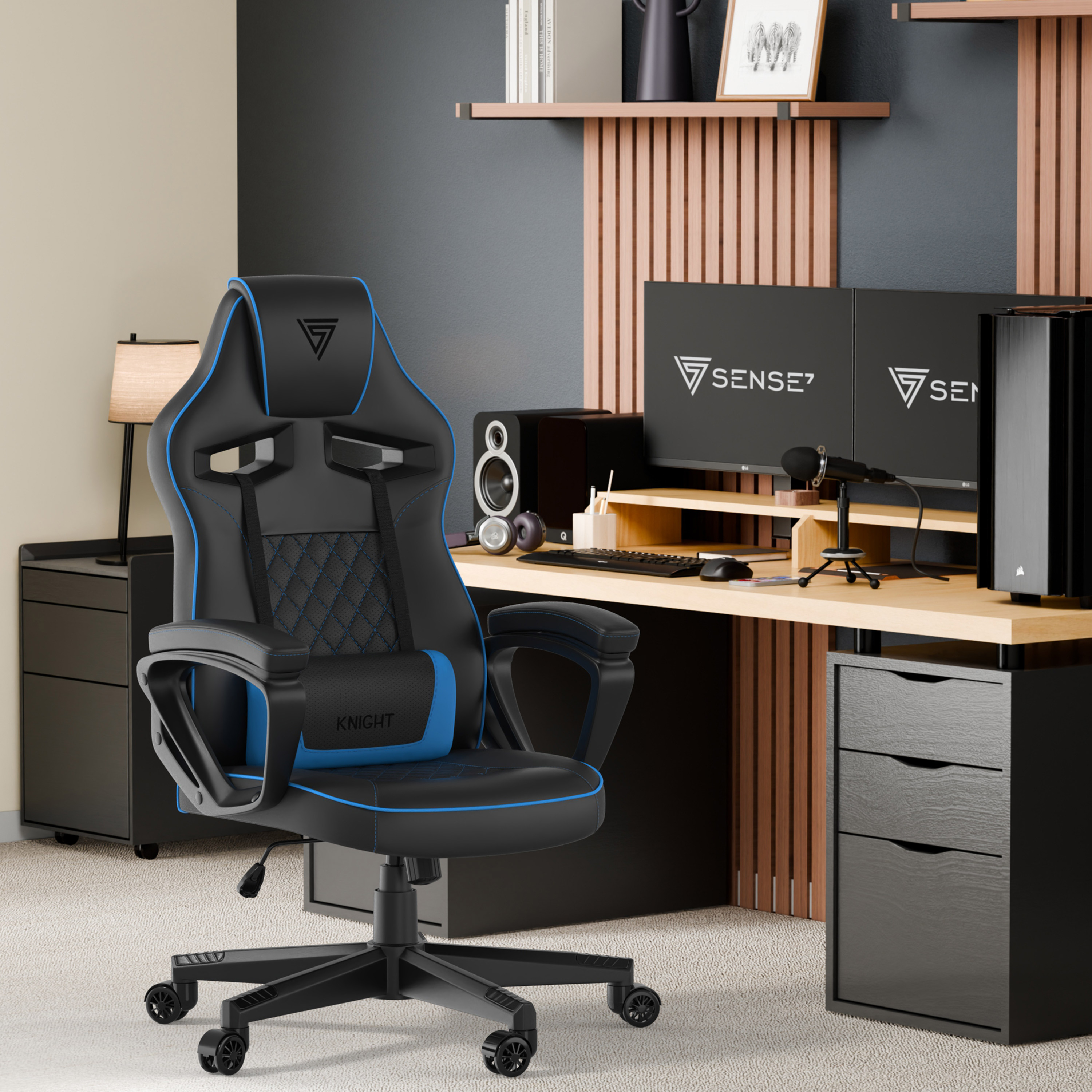 Chaise de jeu dans un bureau à domicile. Deux moniteurs, un microphone et un ordinateur sont visibles. Accents noirs et bleus.