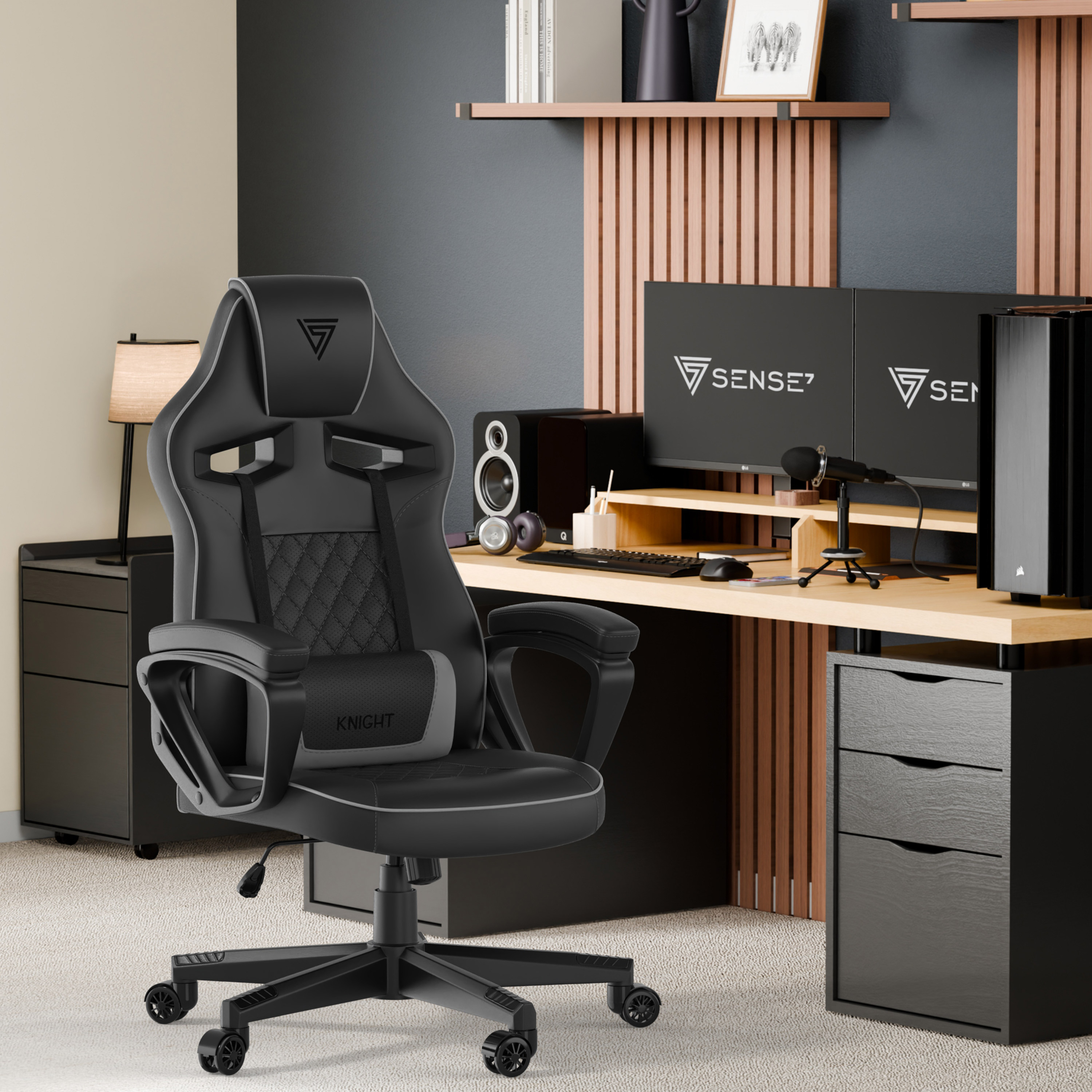 Une configuration de jeu avec une chaise noire, deux moniteurs, un bureau et une tour d'ordinateur. La pièce a des accents en bois et des meubles noirs.