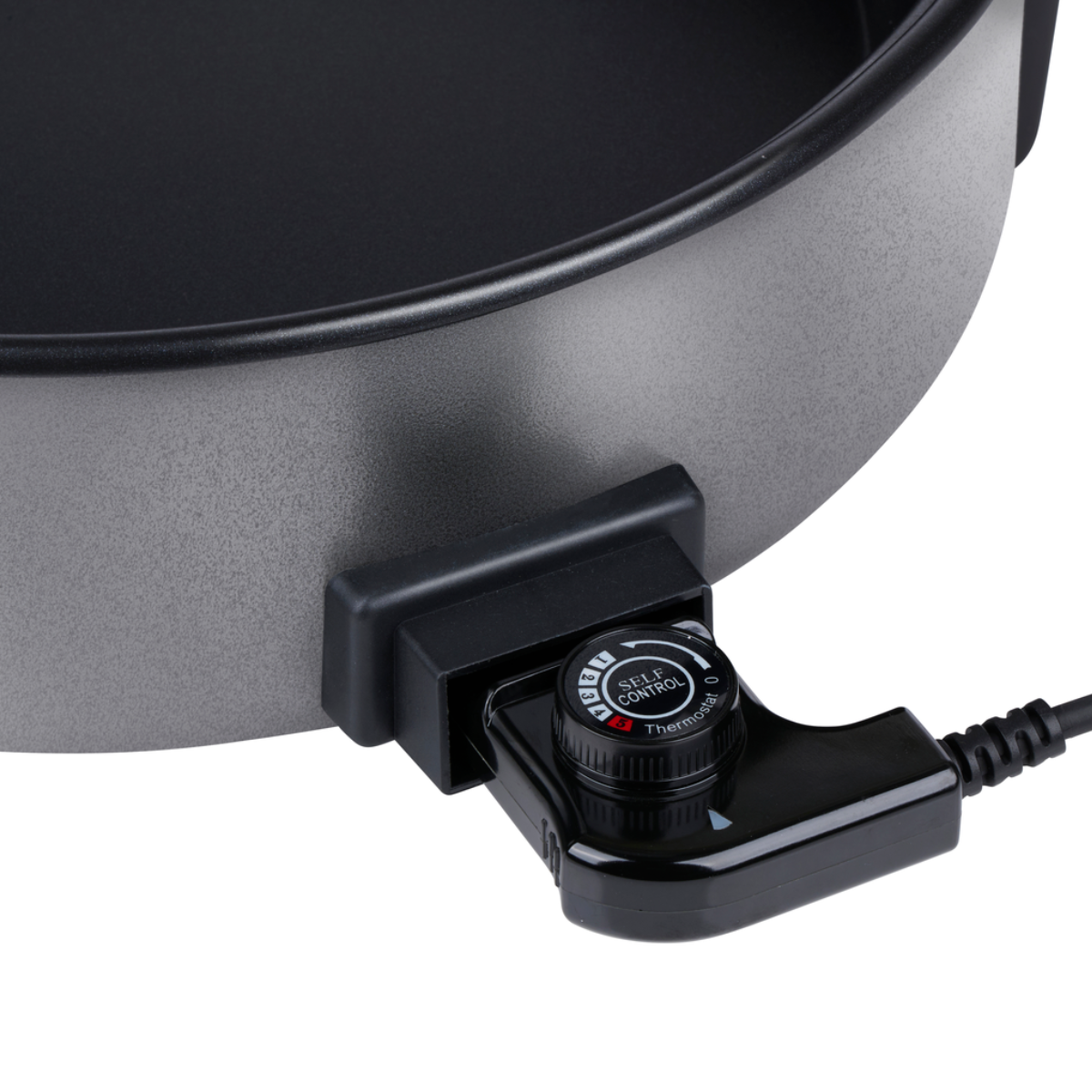 Close-up van een grijze elektrische koekenpan met een zwart bedieningspaneel en draaiknop. De knop toont Self Control Thermostat.
