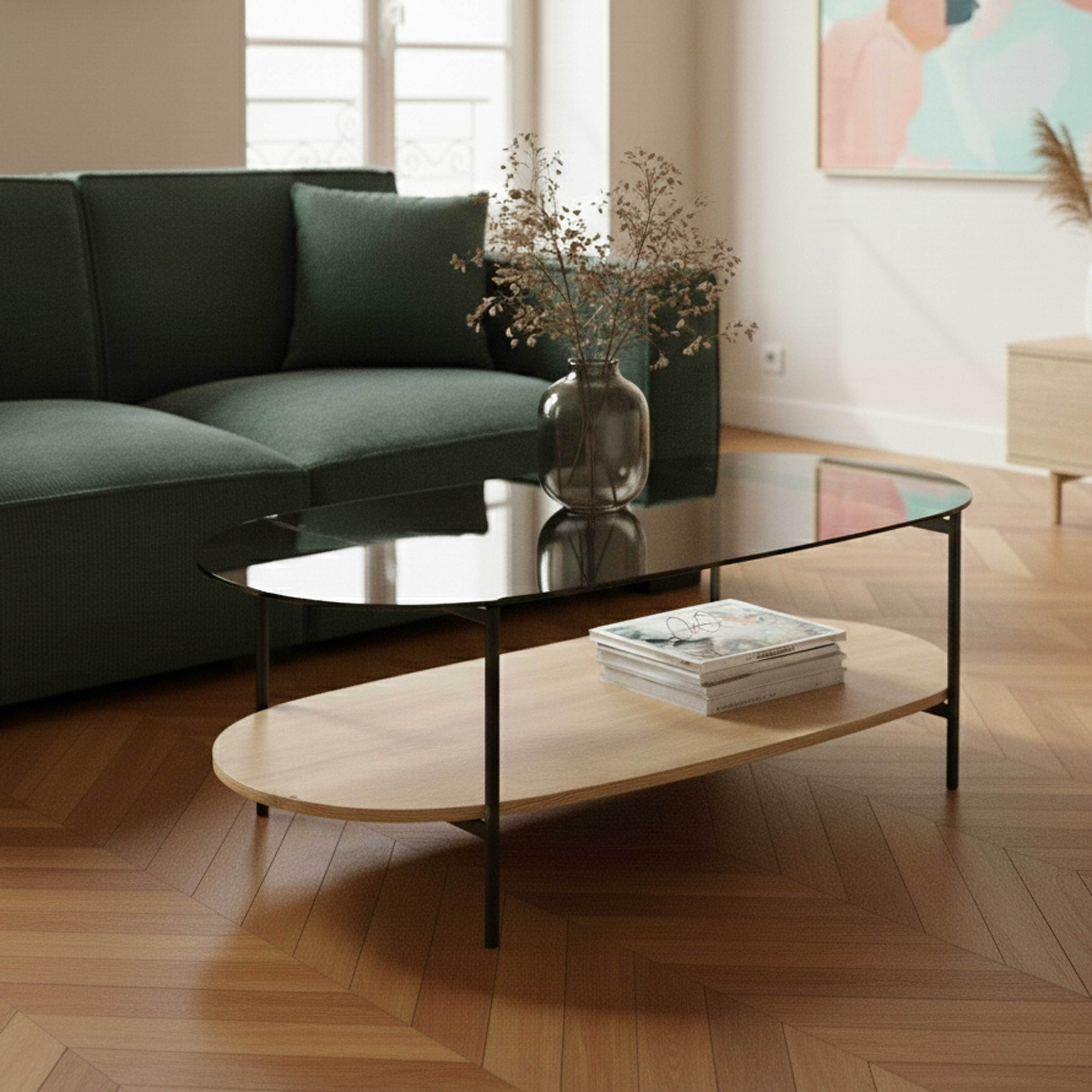 Modernes Wohnzimmer mit grünem Sofa, ovalem Couchtisch und Vase mit Trockenpflanzen. Holzfußboden.