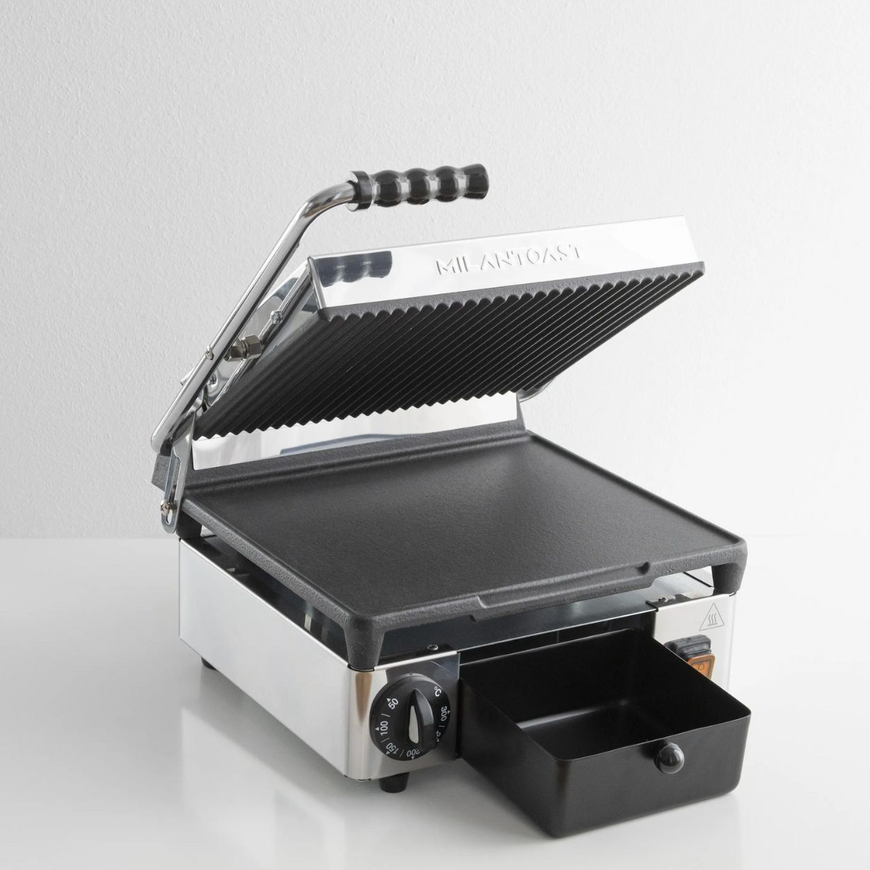 Ein offener Panini-Grill zeigt schwarze Grillplatten und einen Griff. Die Maschine ist aus Edelstahl, mit einer schwarzen Schublade.