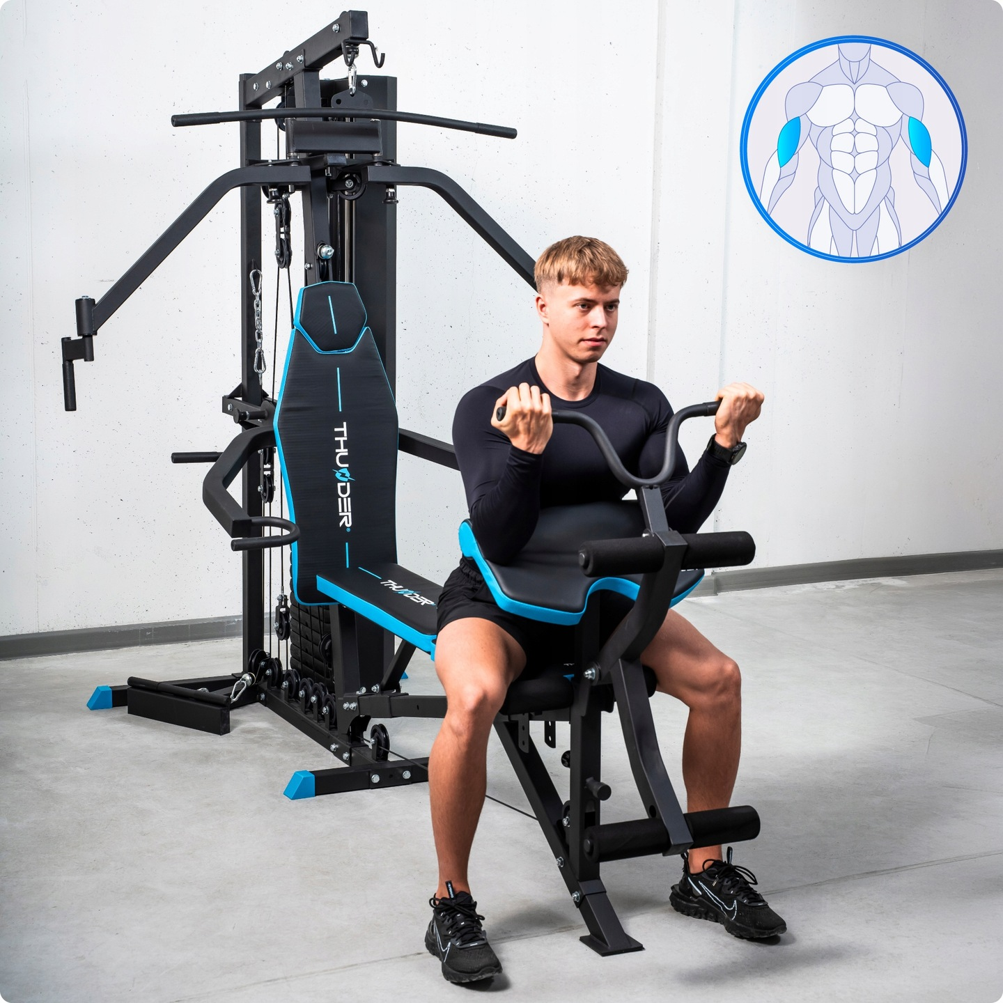 Mężczyzna ćwiczy na czarno-niebieskiej maszynie do ćwiczeń. Ma na sobie czarne ubrania. W tle diagram mięśni.
