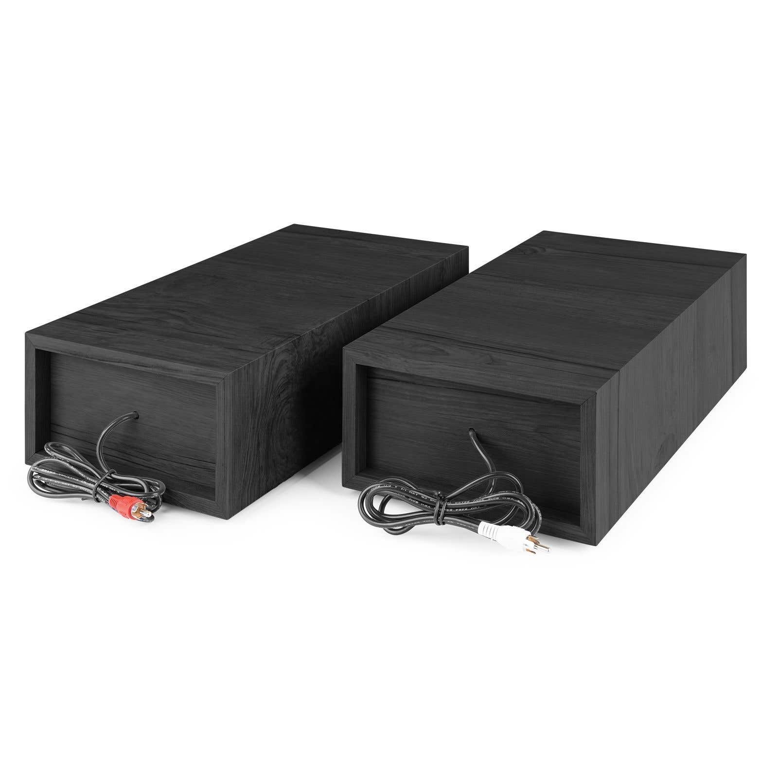 Twee zwarte houten luidsprekers met kabels en stekkers. Eén heeft rode RCA-stekkers, de andere witte stekkers.