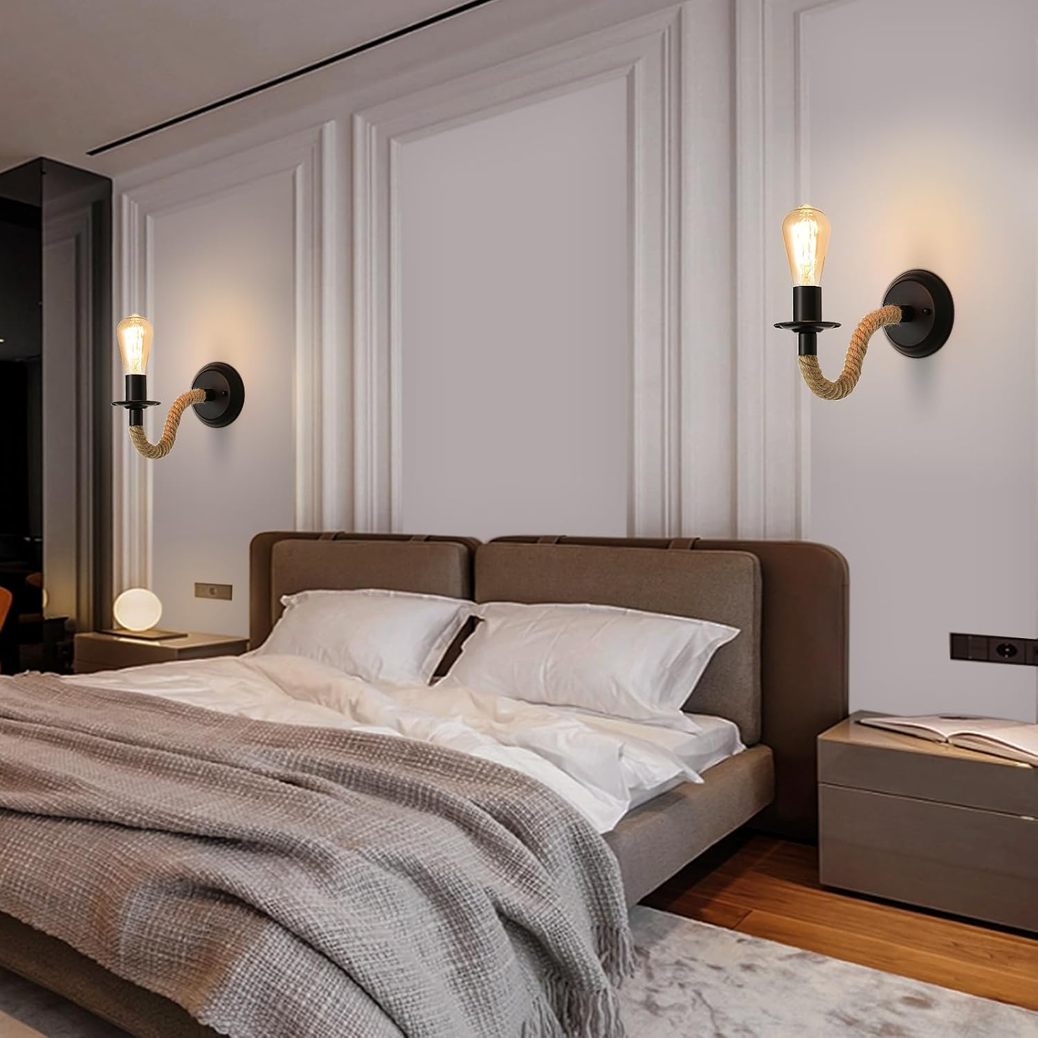 Schlafzimmer mit Bett, zwei Wandlampen und einem Nachttisch. Lampen haben seilumwickelte Arme und Edison-Glühbirnen. Das Bett hat weiße Bettwäsche.