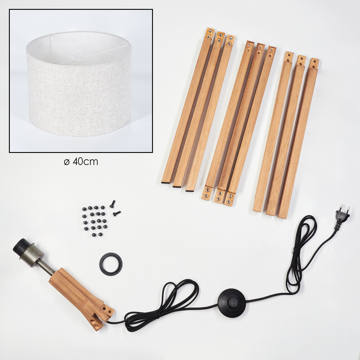 Lampenteile: Lampenschirm, Holzbeine, Schrauben, Lampenfassung, Ring und Netzkabel mit Fußschalter, angeordnet auf weißem Untergrund.
