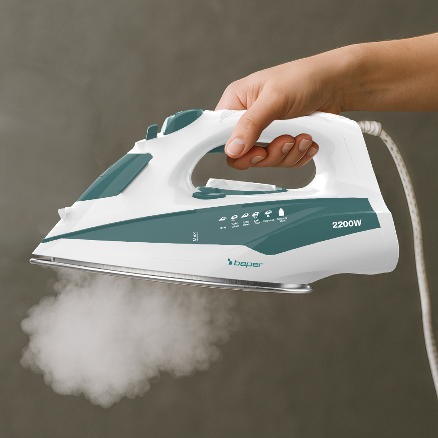 Una mano tiene un ferro da stiro bianco e verde acqua, vapore che esce dalla piastra. Sfondo grigio. Il ferro è un modello 'beper'.