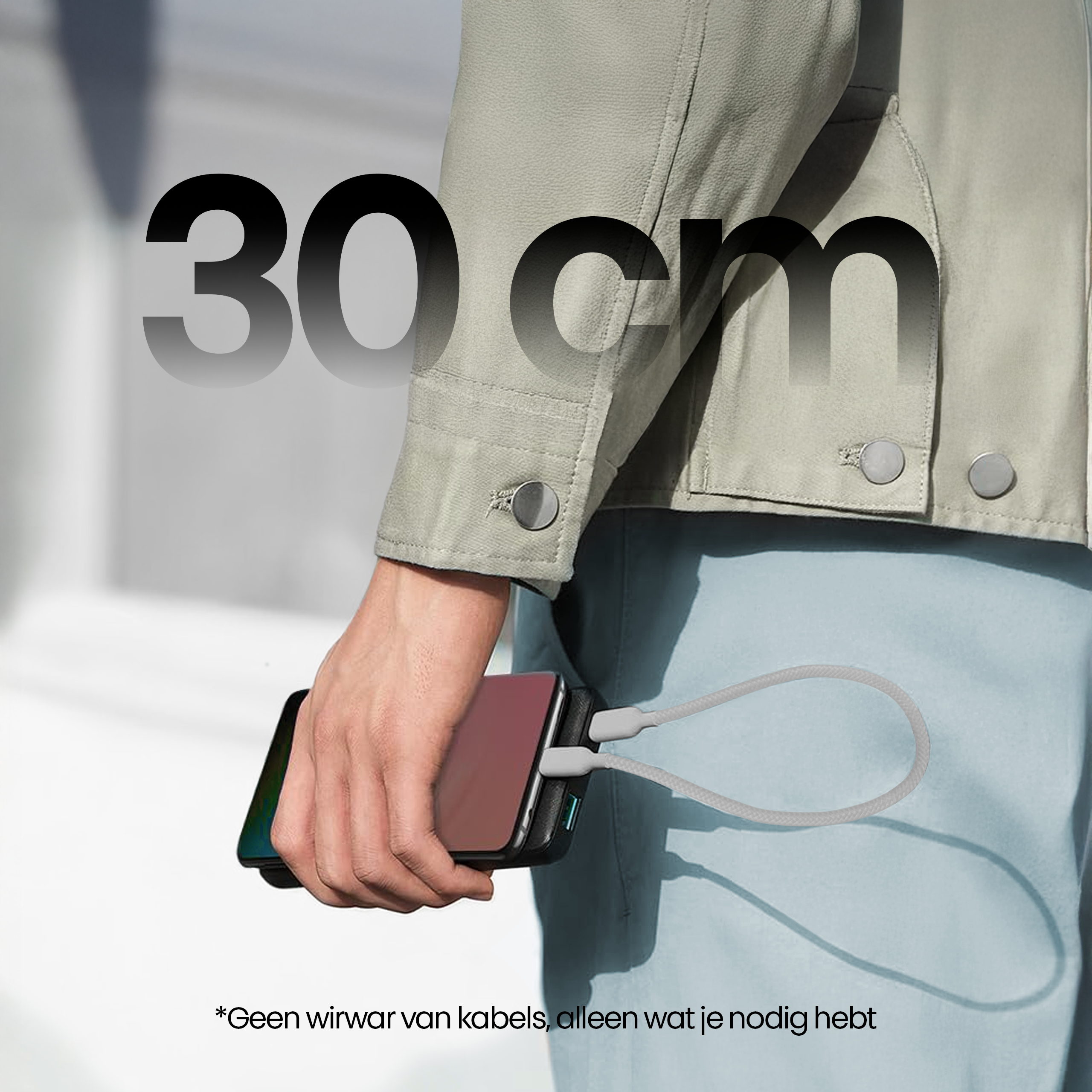 Persoon die een telefoon oplaadt met een kabel. De tekst luidt 30 cm. Lichtgroene jas, blauwe broek. Witte achtergrond.