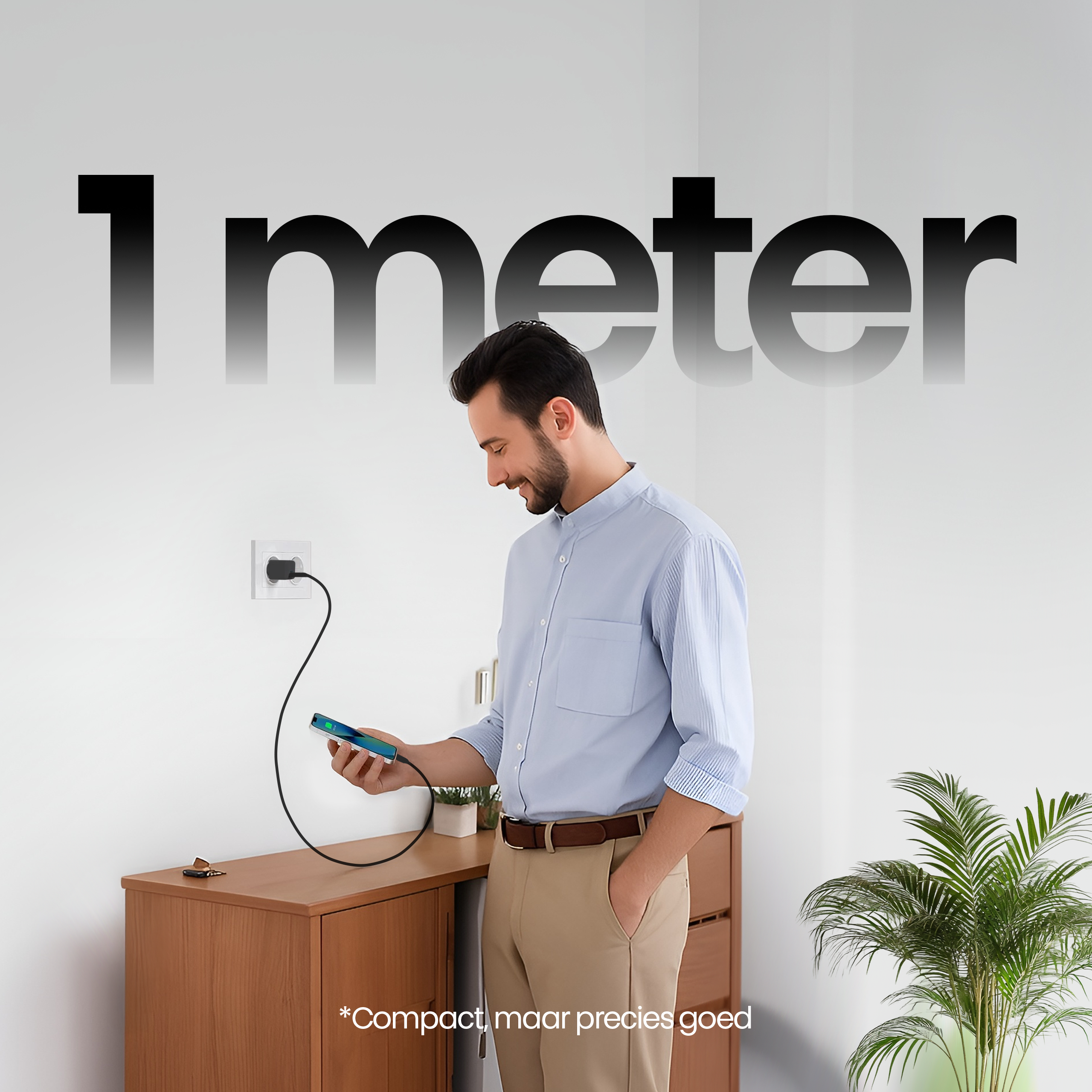 Een man laadt een telefoon op met een zwarte kabel. De tekst luidt '1 meter'. Een houten kast en een plant zijn in de scène.