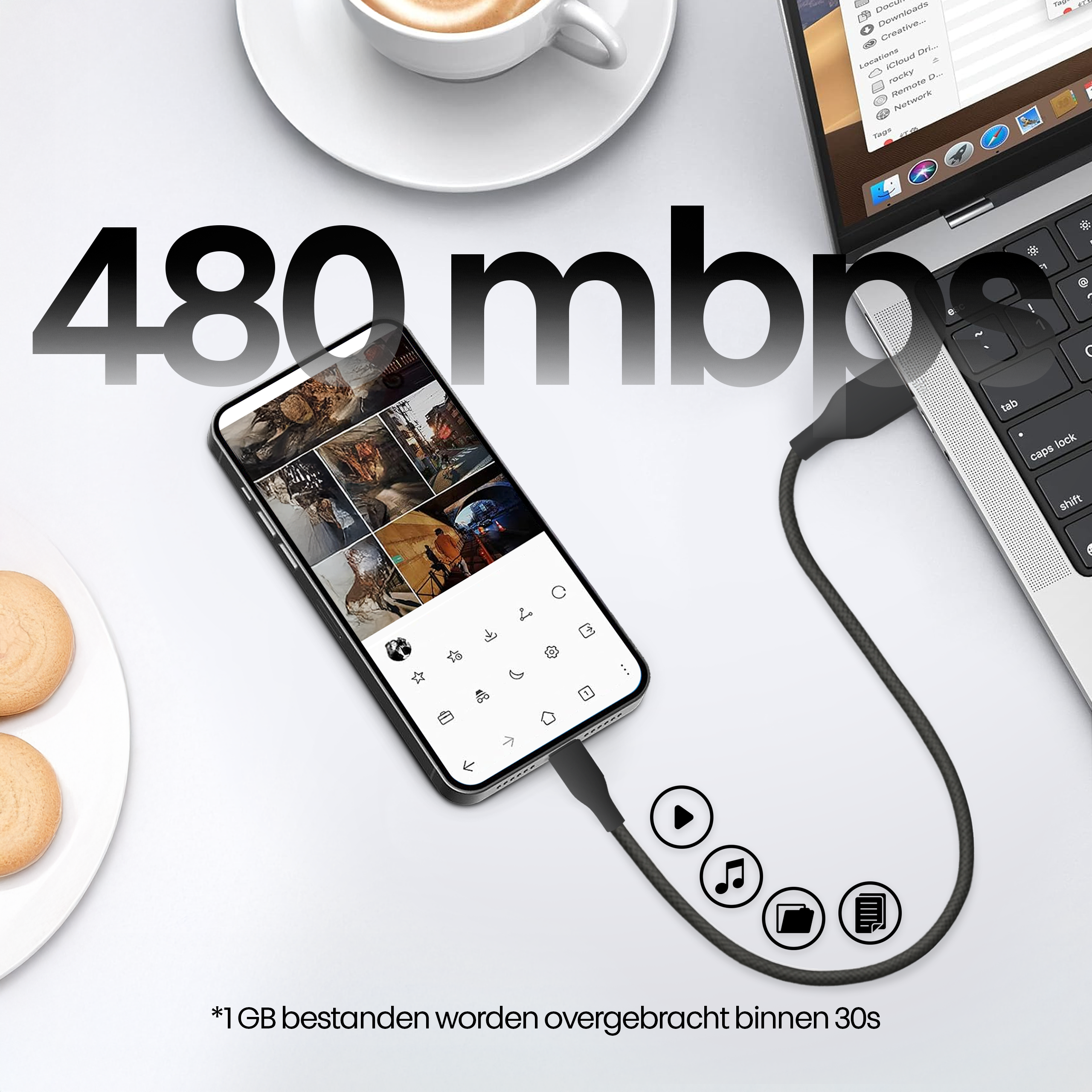 A phone connected to a laptop with a USB cable. The phone displays images. A cup of coffee and cookies are in the background.